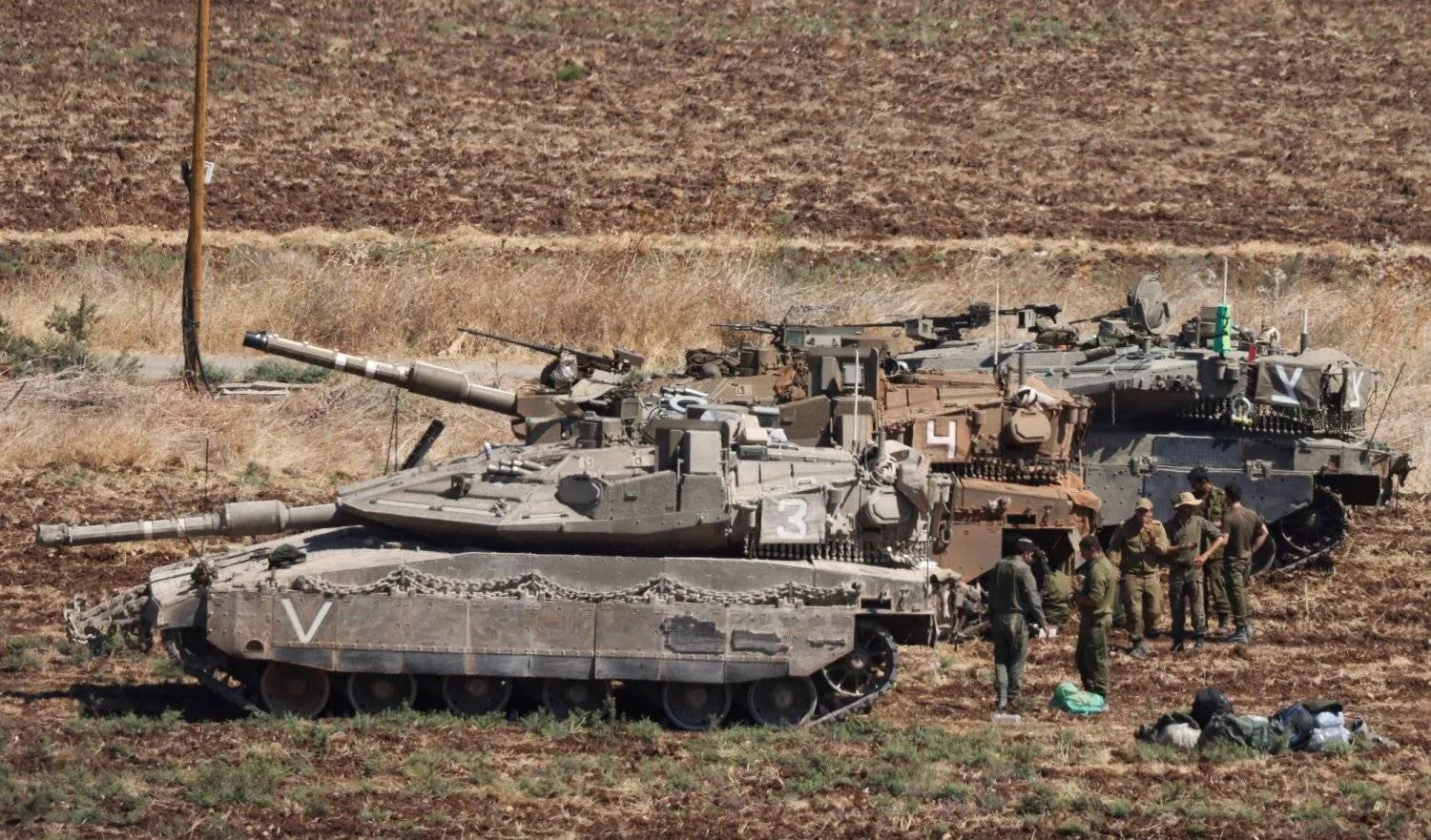 Soldiers stand next to Israeli Army tanks, amid cross-border hostilities between Hezbollah and Israel, in northern Israel, September 27, 2024. REUTERS/Jim Urquhart 