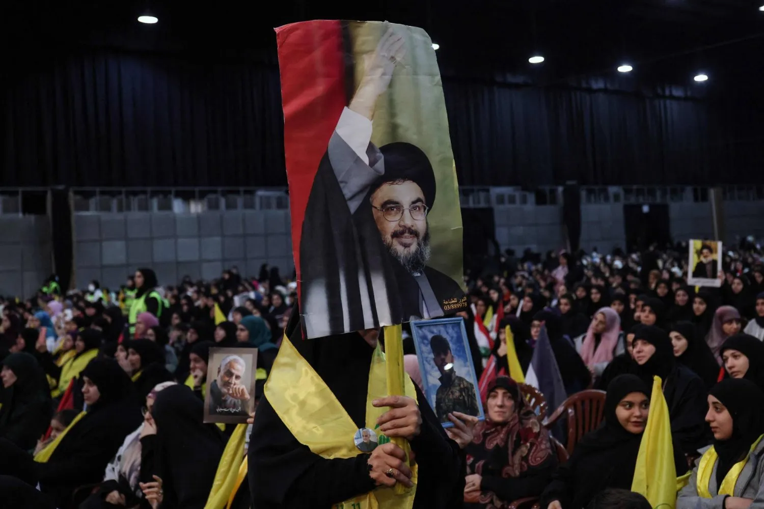 Hizbullah destekçileri Kasım Süleymani'nin öldürülmesinin ardından güney banliyölerinde düzenlenen kutlamada Nasrallah'ın bir resmini tutuyor (AFP)