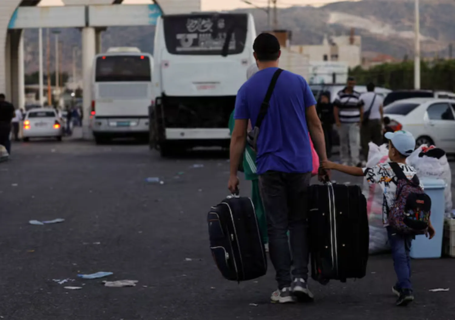 Syrians, who were living in Lebanon and returned to Syria due to ongoing hostilities between Hezbollah and Israeli forces, carry belongings at the Syrian-Lebanese border, in Jdaydet Yabous, Syria, September 25, 2024. REUTERS/Yamam al Shaar/File Photo