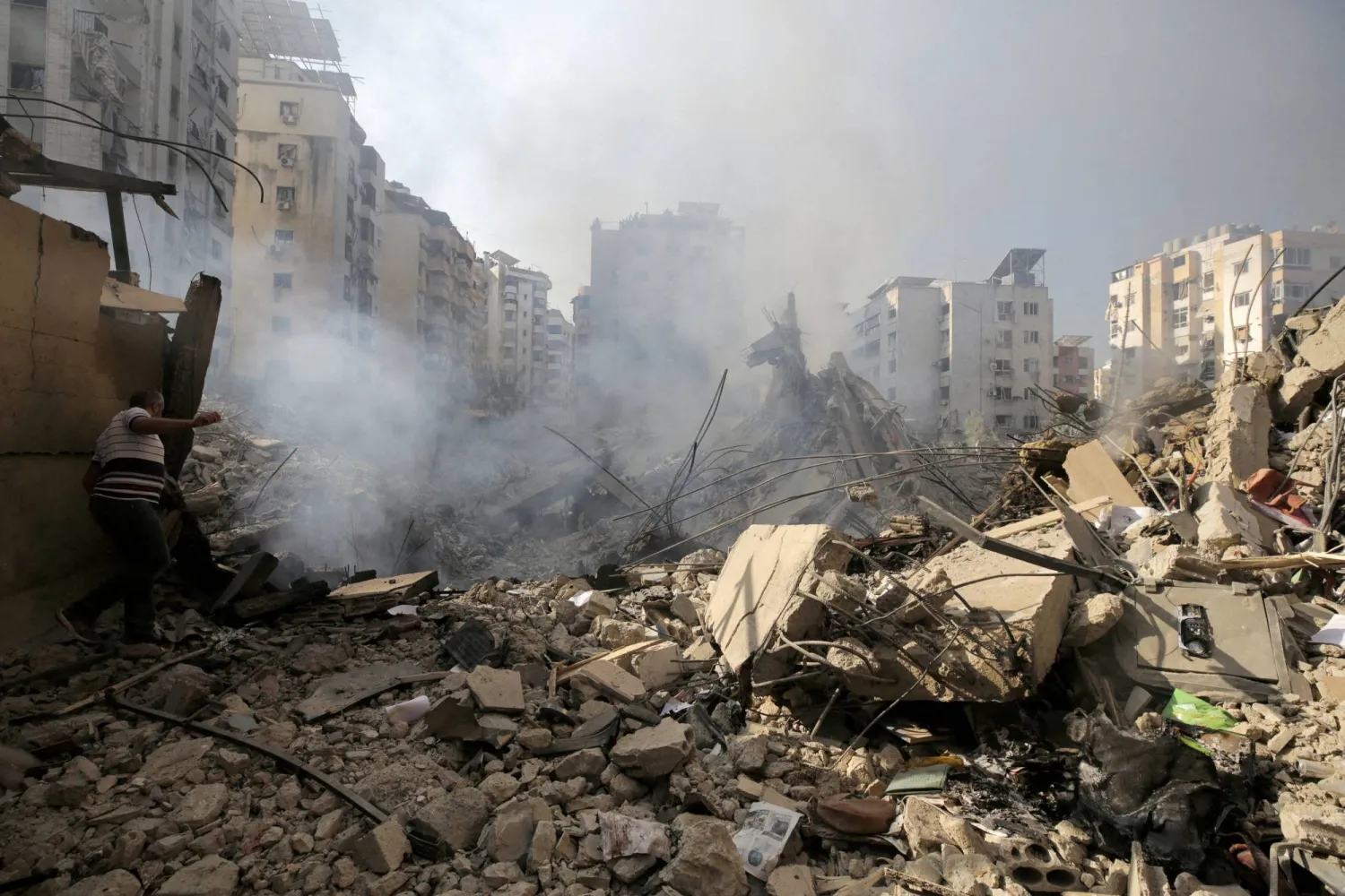 A man walks on the rubble of damaged buildings in the aftermath of Israeli airstrikes on Beirut's southern suburbs, Lebanon September 28, 2024. REUTERS/Ali Alloush