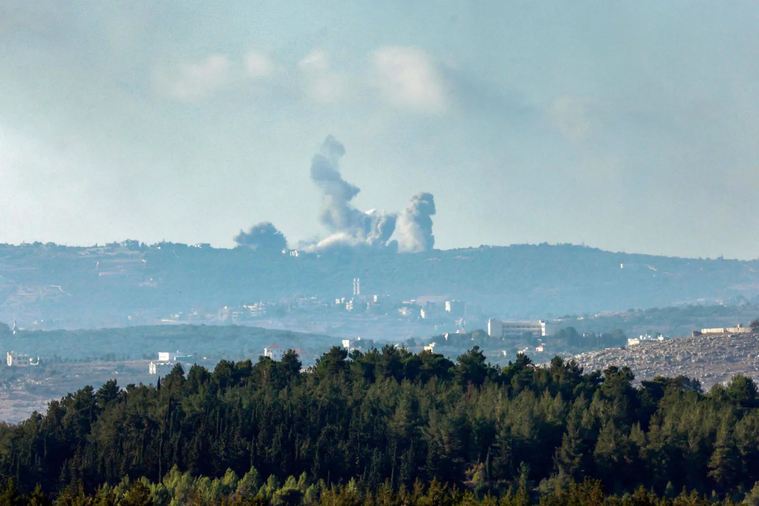 أعمدة الدخان تتصاعد في أعقاب القصف الإسرائيلي على جنوب لبنان من موقع على طول الحدود بشمال إسرائيل (أ.ف.ب)