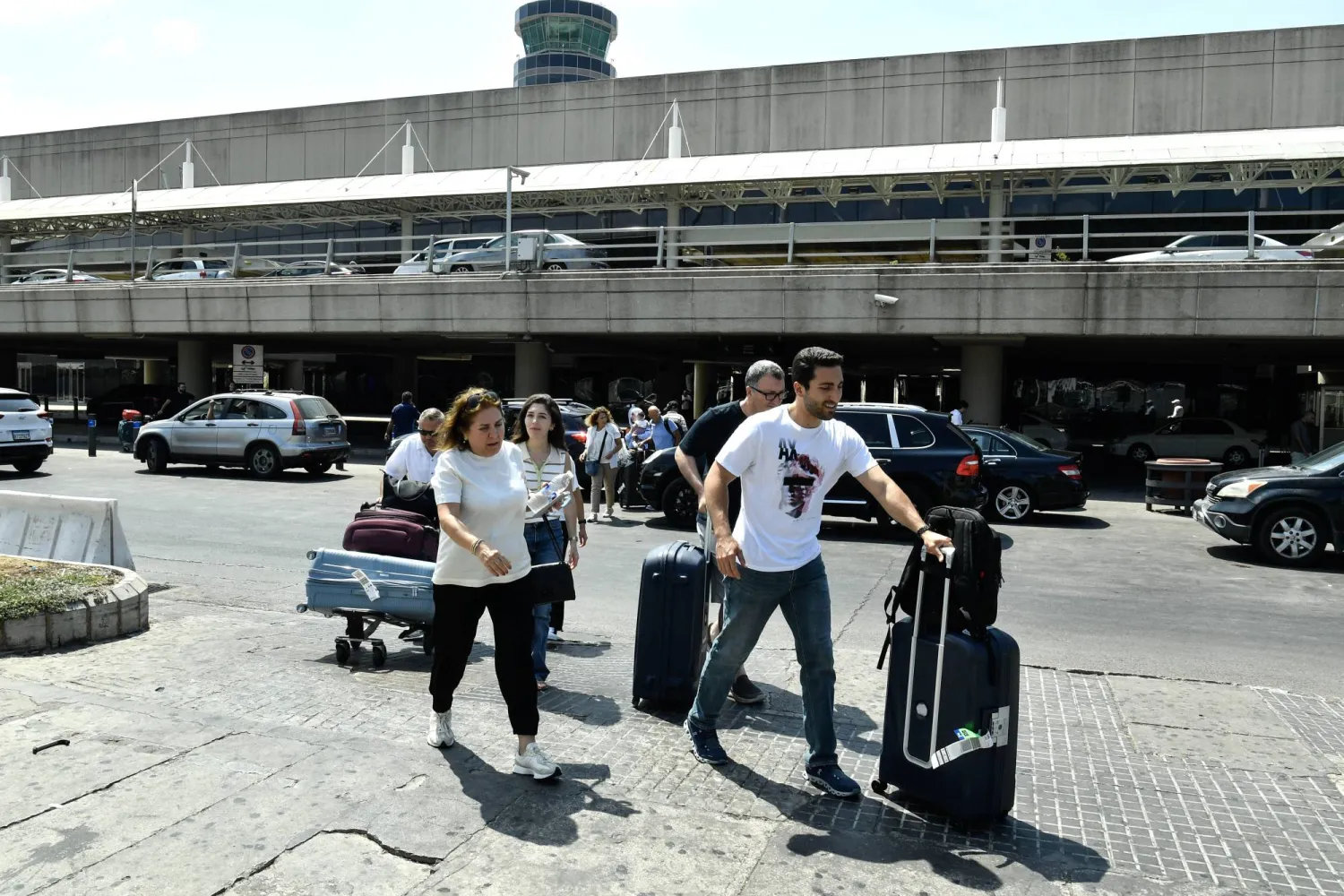 مسافرون يخرجون من مطار بيروت الدولي بعد التصعيد العسكري بين «حزب الله» وإسرائيل (إ.ب.أ) 