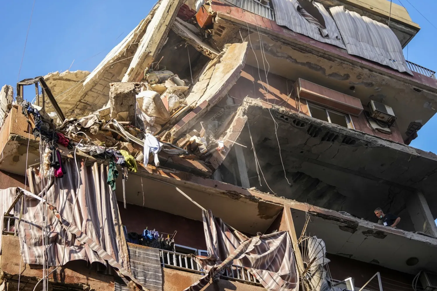 Residents check a partially destroyed building at the site of an Israeli airstrike in Beirut's southern suburbs, Tuesday, Sept. 24, 2024. (AP) 