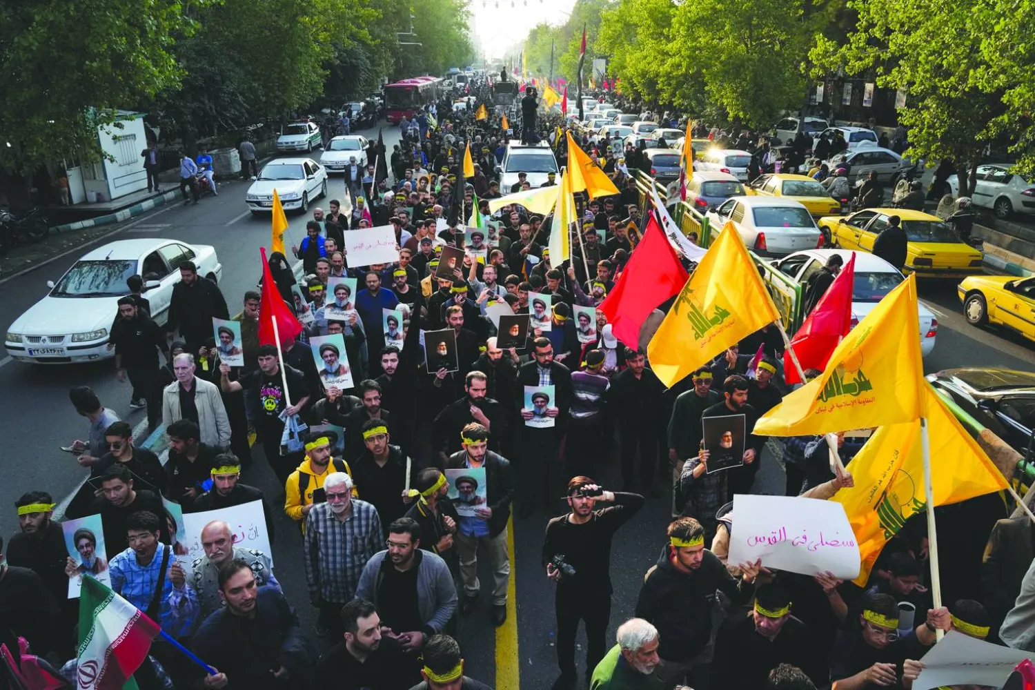 إيرانيون يرفعون صور حسن نصر الله وأعلام «حزب الله» في مسيرة وسط طهران الثلاثاء (أ.ب)