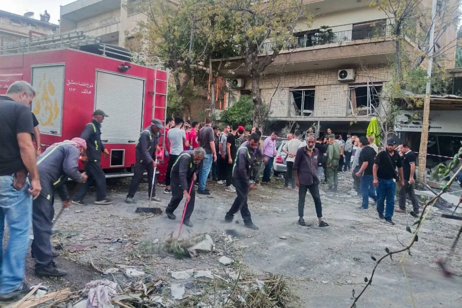 Emergency service personnel and residents gather at the site of an Israeli strike in Syria's capital Damascus on October 2, 2024. (AFP)