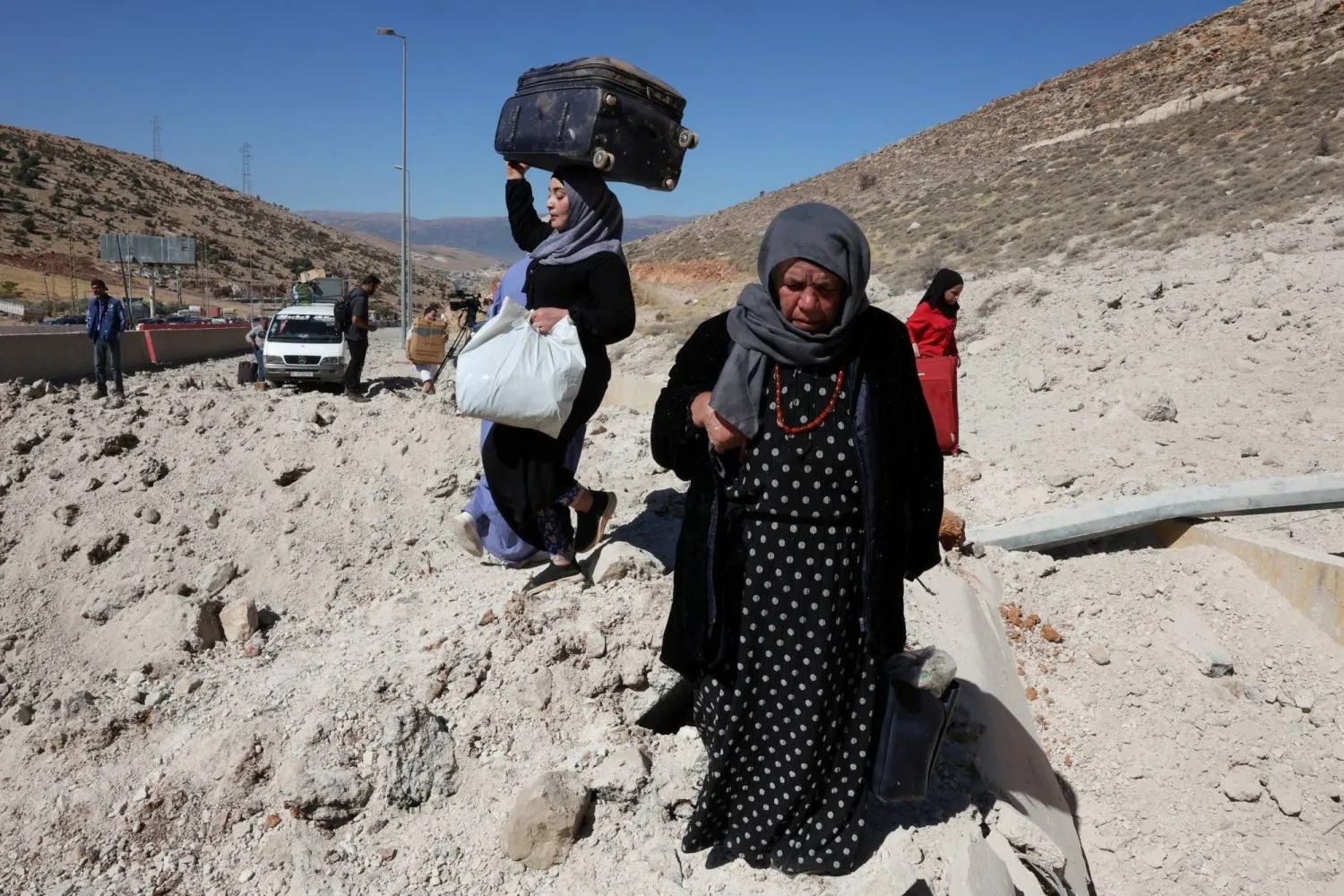  İsrail'in Beyrut'un güney banliyösüne düzenlediği saldırılar sonrasında yerinden edilen insanlar eşyalarını taşıyor (Reuters)