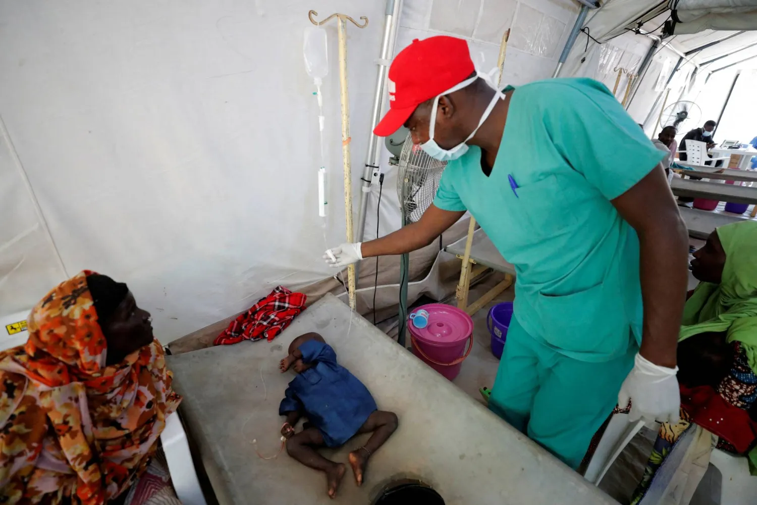 FILE PHOTO: A health worker at the Medecins Sans Frontieres (MSF - Doctors without Borders) Cholera Treatment Center, checks intravenous fluid for a newly arrived cholera patient Ali Bakura, 3, in Maiduguri, Borno State, Nigeria October 18, 2022. REUTERS/Christophe Van Der Perre/File Photo
