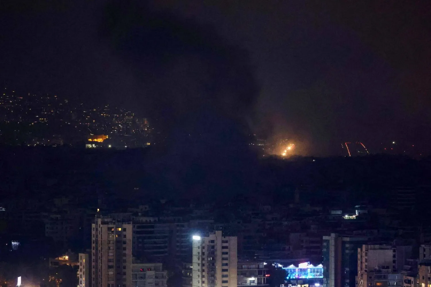 İsrail'in pazartesi gecesi düzenlediği yoğun hava saldırılarının ardından Beyrut'un güney banliyölerindeki çeşitli bölgelerden duman bulutları yükselirken, 7 Ekim 2024 (AFP)