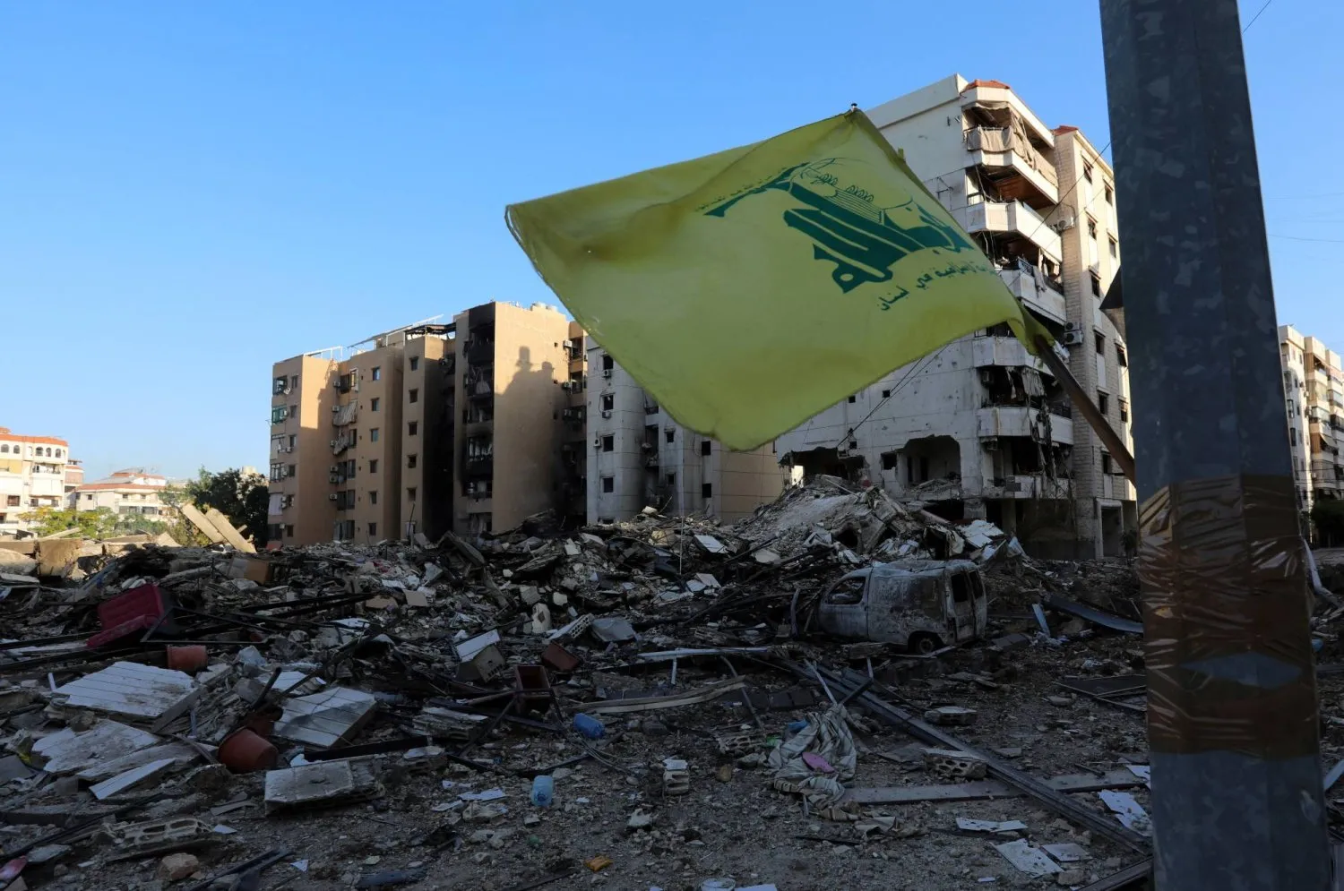 İsrail'in Beyrut'un güney banliyösüne düzenlediği saldırıların ardından hasar gören bölgedeki Hizbullah bayrağı, 8 Ekim 2024 (Reuters)