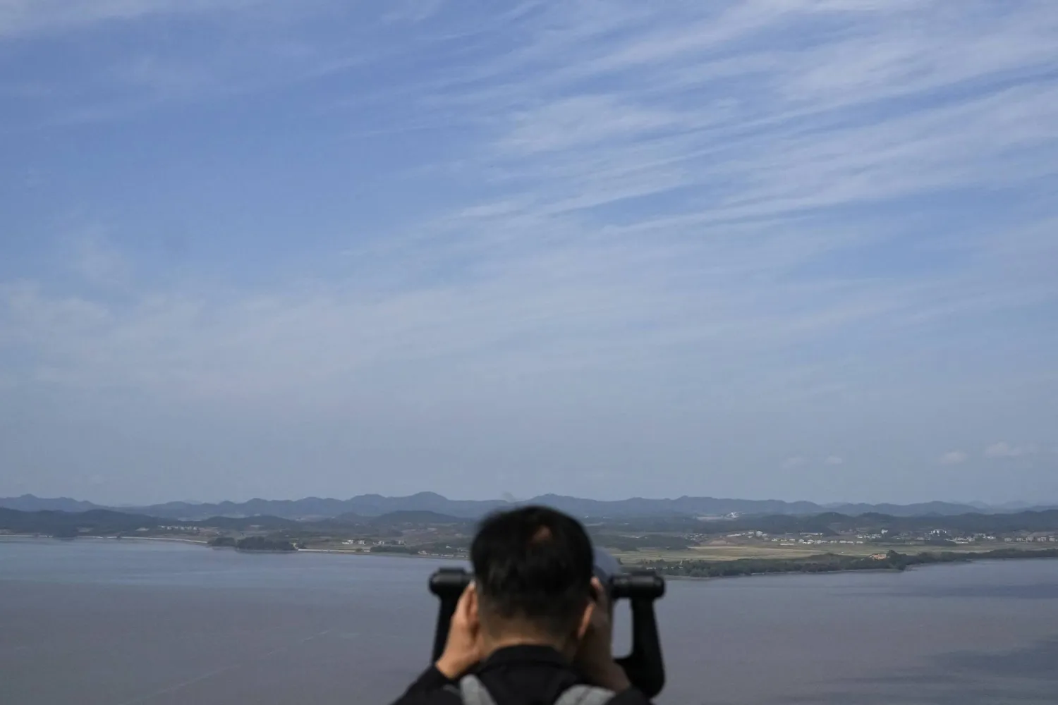 A visitor watches North Korean side from the Unification Observation Post in Paju, South Korea, Wednesday, Oct. 9, 2024. (AP Photo/Lee Jin-man)