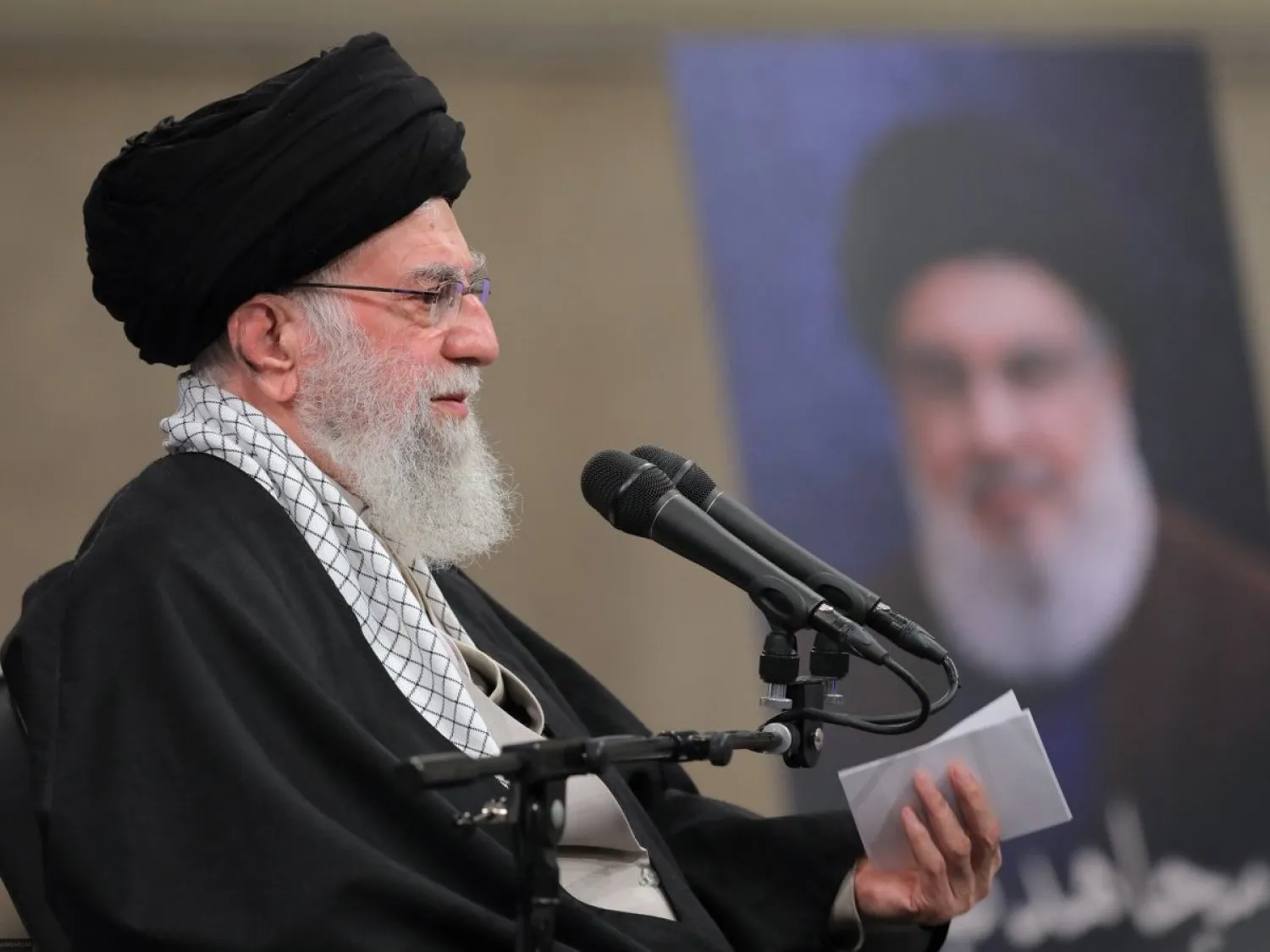  Hamaney, arka planda Nasrallah'ın resmi, bir grup destekçisine konuşuyor (El-Mürşid web sitesi)