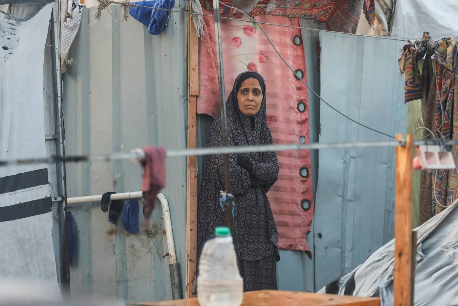 فلسطينية تنظر بحزن إلى حطام الخيام بعد ليلة من الرعب في محيط «مستشفى شهداء الأقصى» (رويترز)