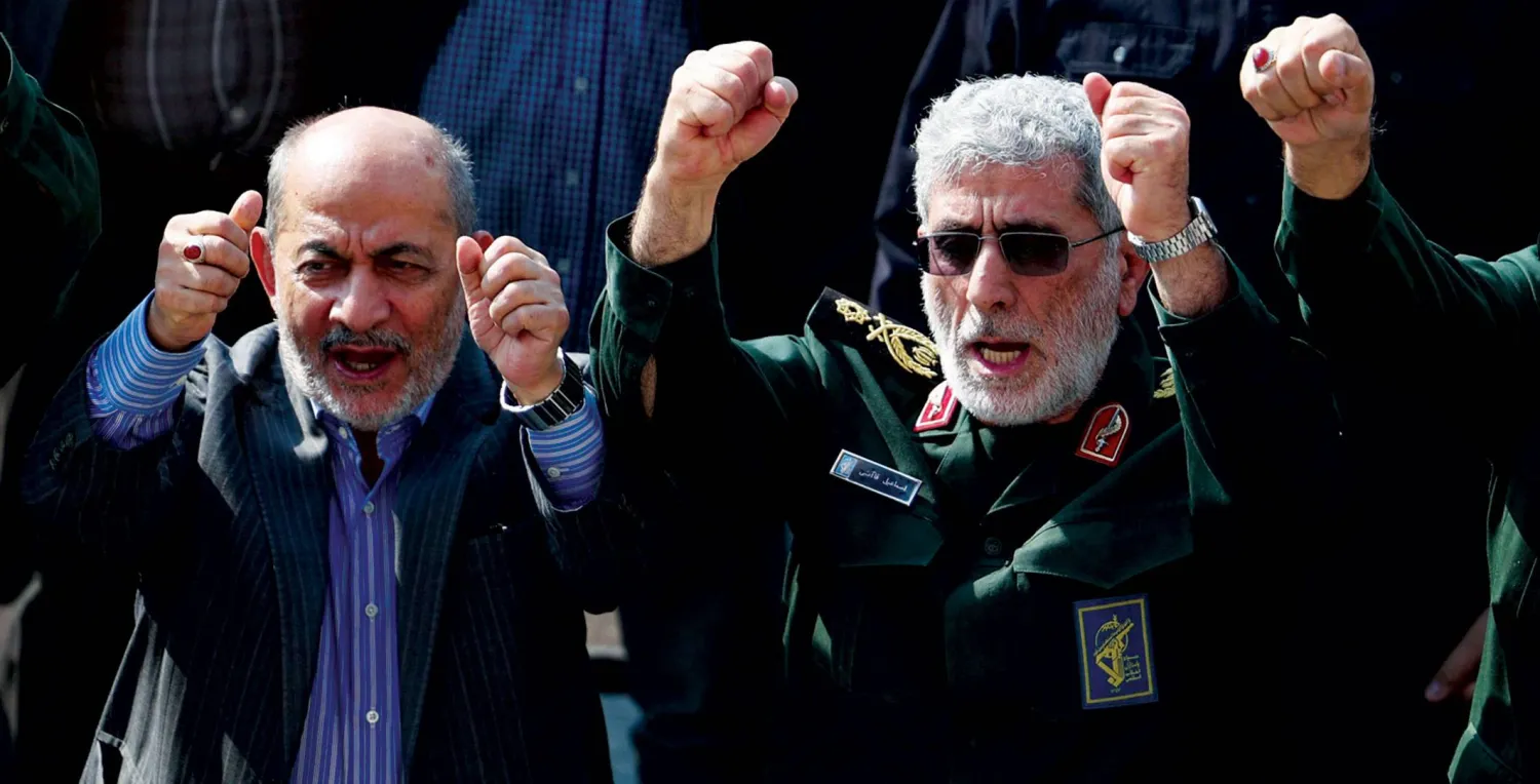  قاآني والقيادي في «الحرس الثوري» حسين علايي يرددان هتافات في تشييع نيلفروشان أمس (أ.ف.ب)
