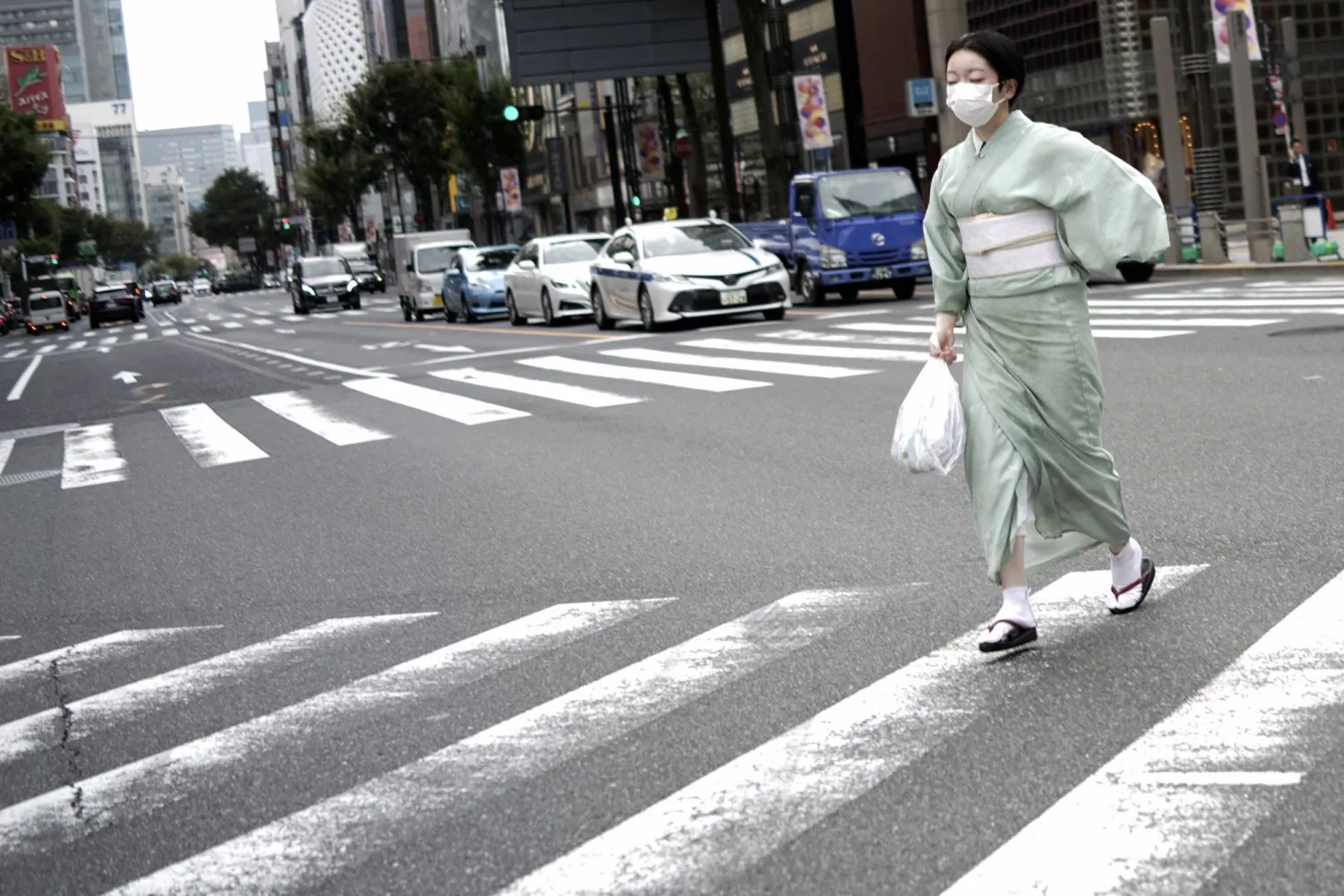 امرأة يابانية مرتدية الزي التقليدي «الكيمونو» تعبر طريقاً وسط العاصمة طوكيو (أ.ب)