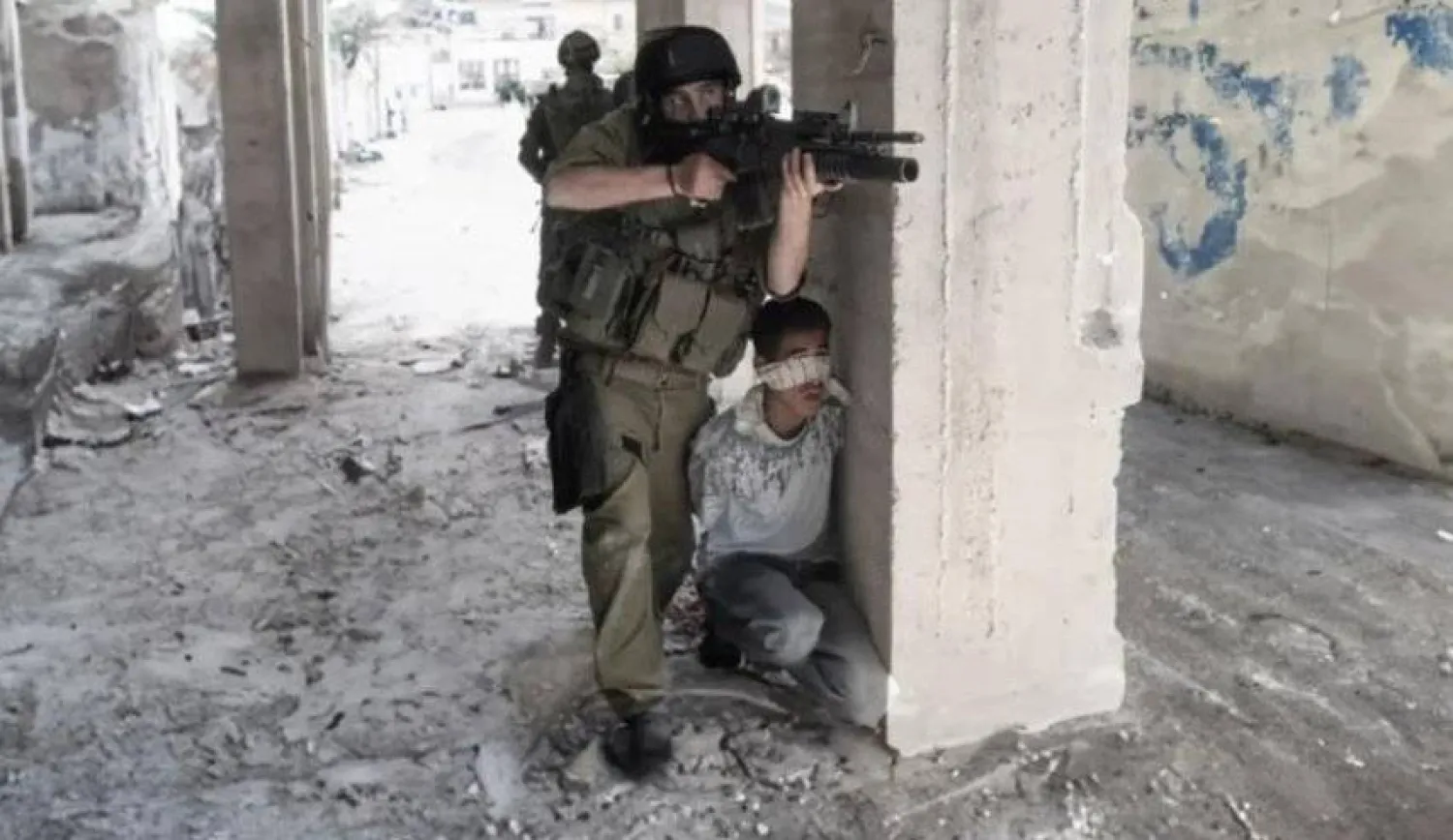 أرشيفية لجندي إسرائيلي يتخذ من طفل فلسطيني درعا بشرية في غزة