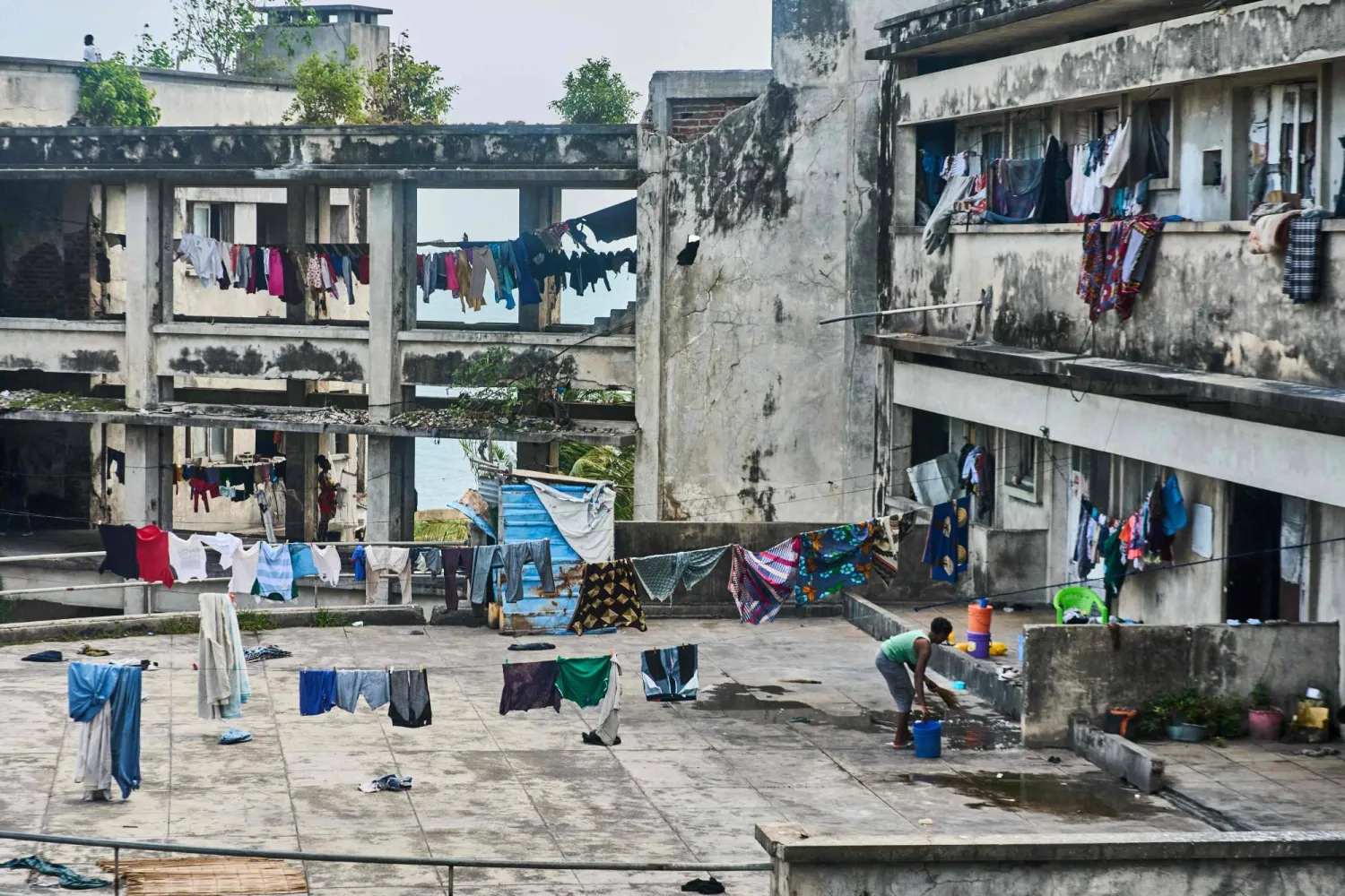 A woman sweeps the veranda at the Grande Hotel in Beira, Mozambique on October 12, 2024. (Photo by Zinyange Auntony / AFP)