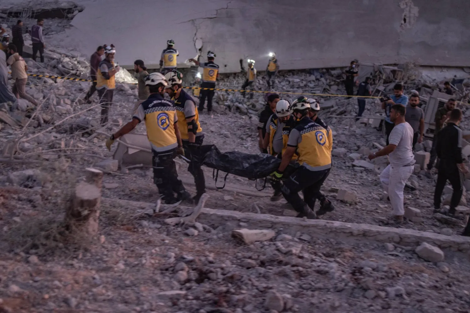 أفراد من الدفاع المدني السوري يعملون في موقع غارة جوية روسية على مشارف مدينة إدلب (د.ب.أ)