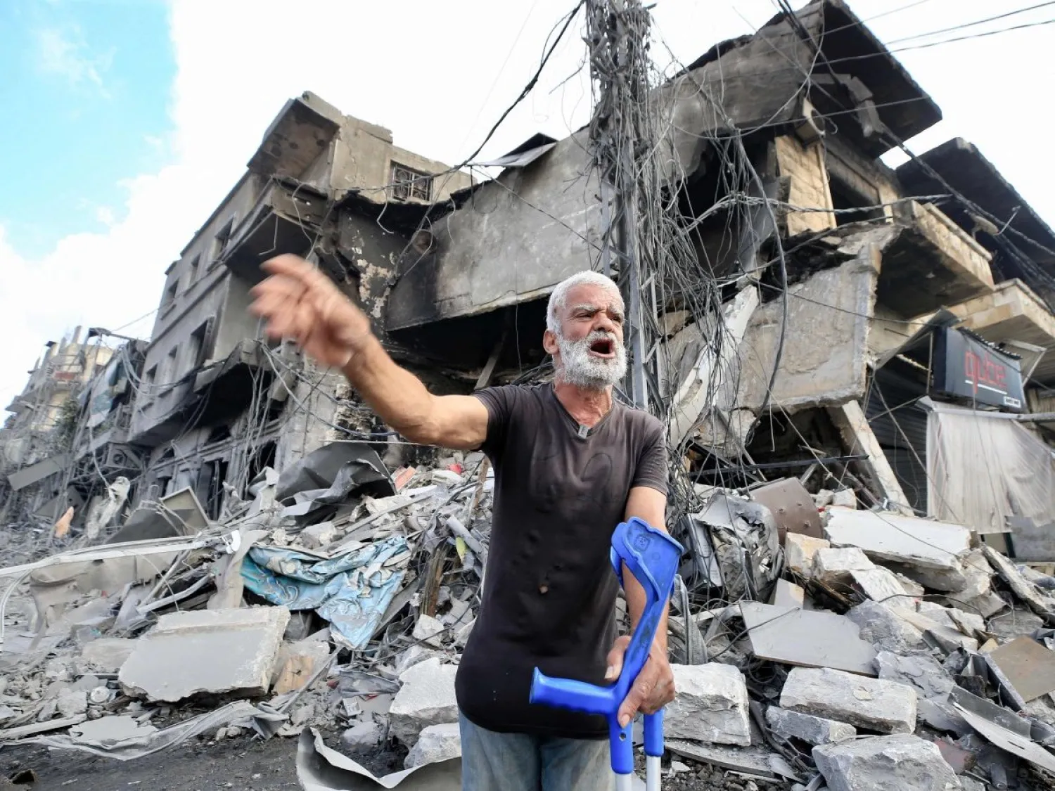 لبناني على عكازه أمام دمار هائل خلفته غارات إسرائيلية على النبطية (أ.ف.ب)