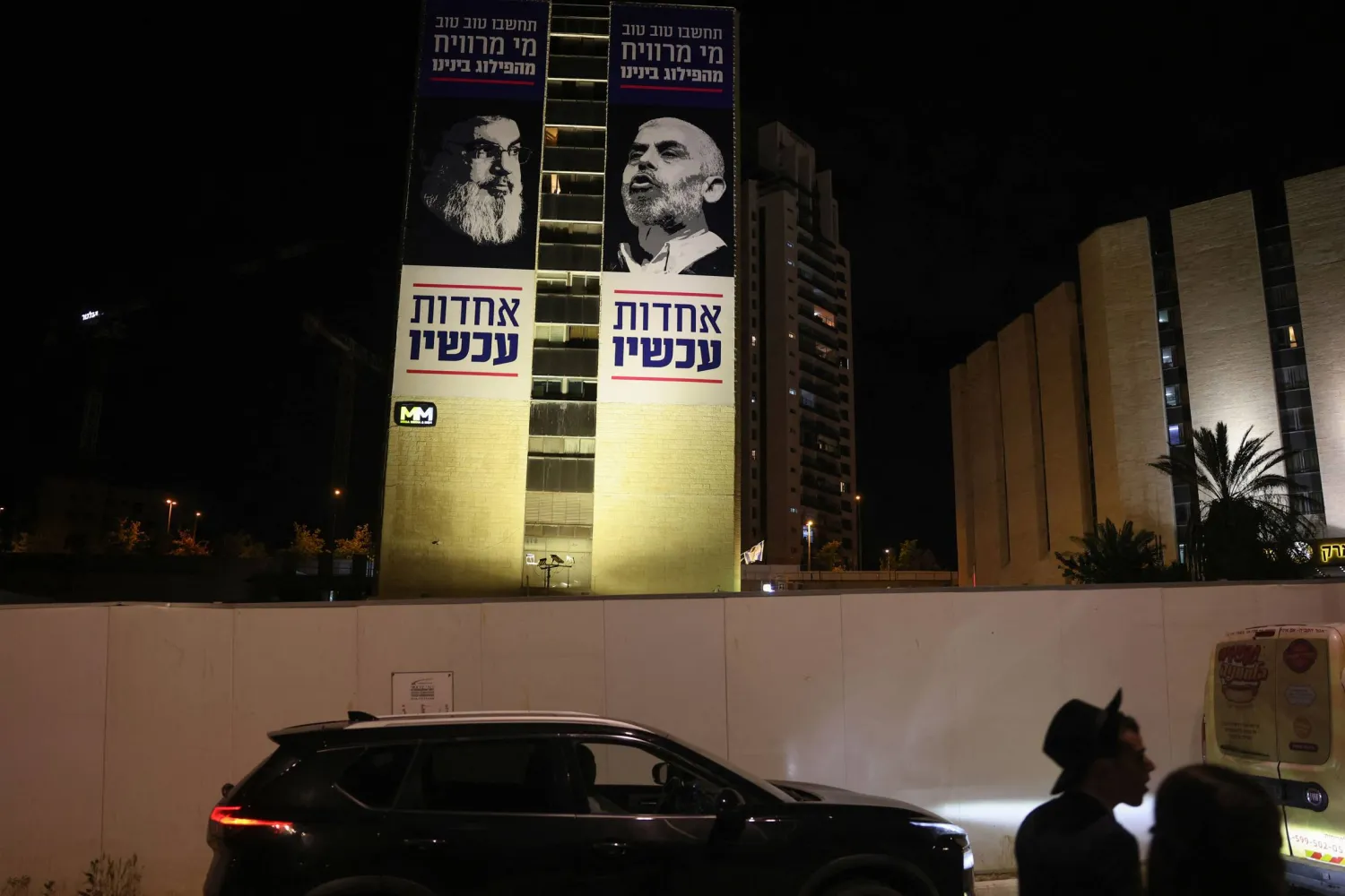 لوحة إعلانية في أحد شوارع القدس تحمل صورة يحيى السنوار وحسن نصر الله وكُتب عليها بالعبرية: «من يستفيد من فُرقتنا؟ الوحدة الآن» (أ.ف.ب)