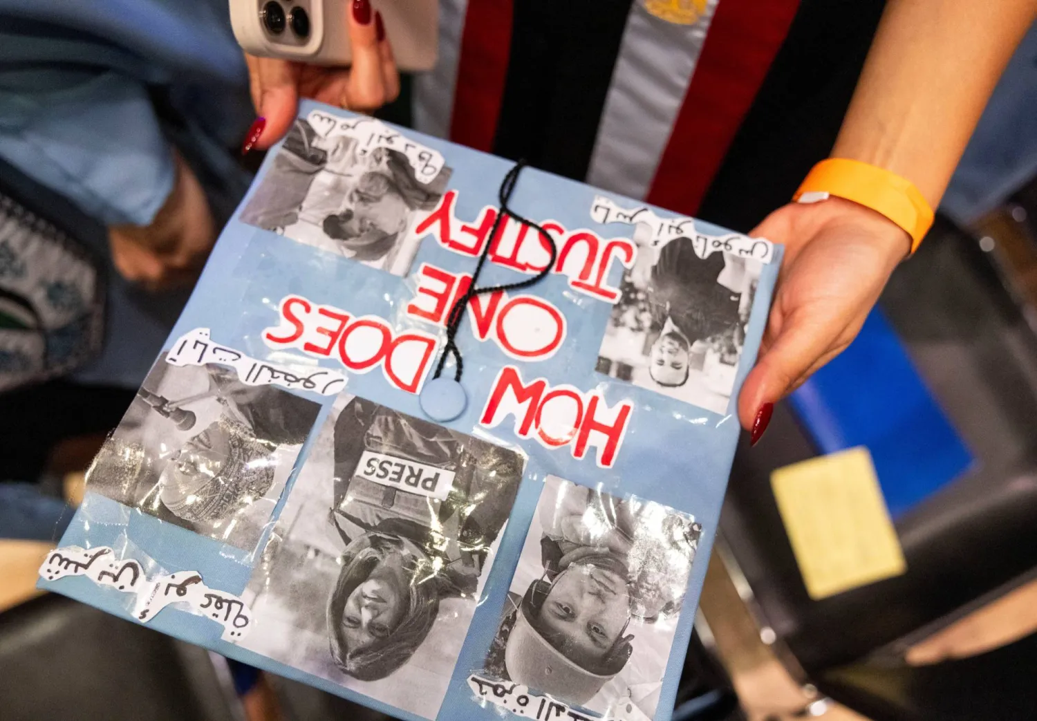 A student holds their hat decorated with statements on their graduation outfit in support of journalism colleagues on the day of a graduation ceremony at Columbia University Journalism School, during the ongoing conflict between Israel and the Palestinian group Hamas, in New York City, US, May 15, 2024.  REUTERS/Caitlin Ochs