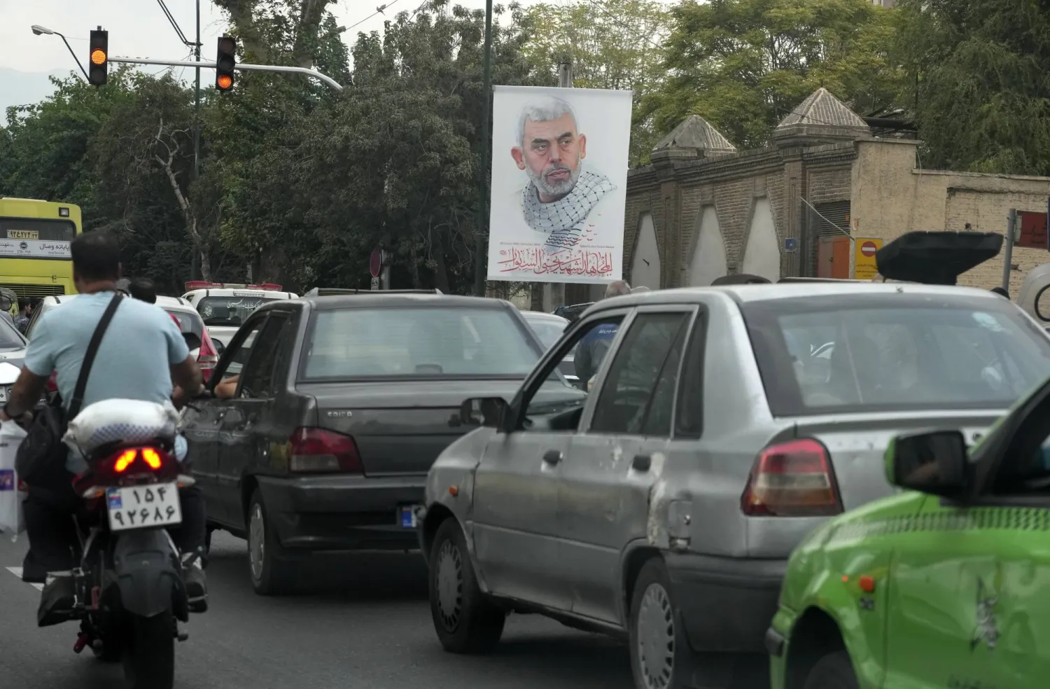 Vehicles drive past a banner of Hamas leader Yahya Sinwar, who was killed by Israeli forces in Gaza on Wednesday, in downtown Tehran, Iran, Saturday, Oct. 19, 2024. (AP Photo/Vahid Salemi)