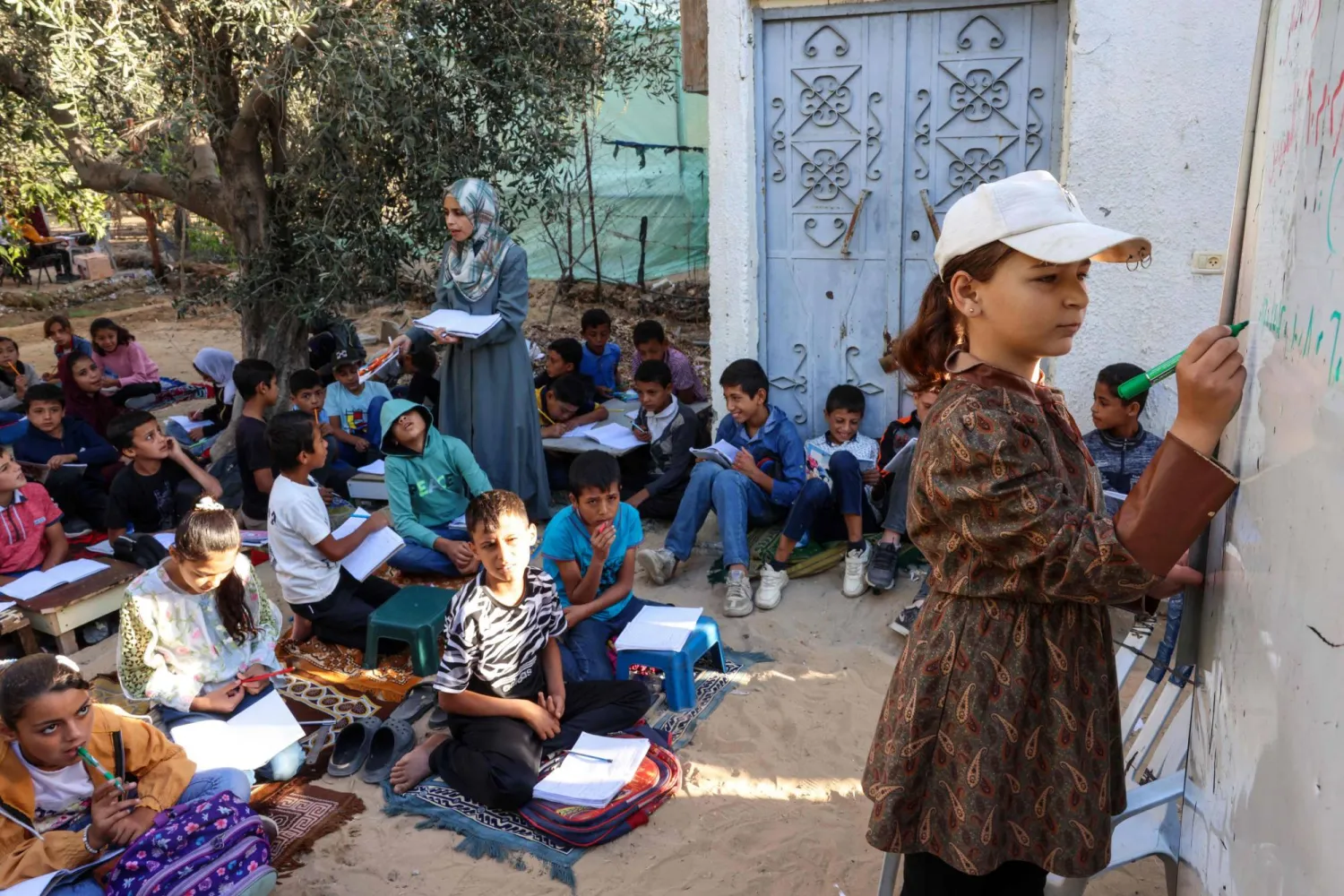 أطفال فلسطينيون نازحون يحضرون فصلاً دراسياً في مدرسة مؤقتة في خان يونس جنوب قطاع غزة (أ.ف.ب)