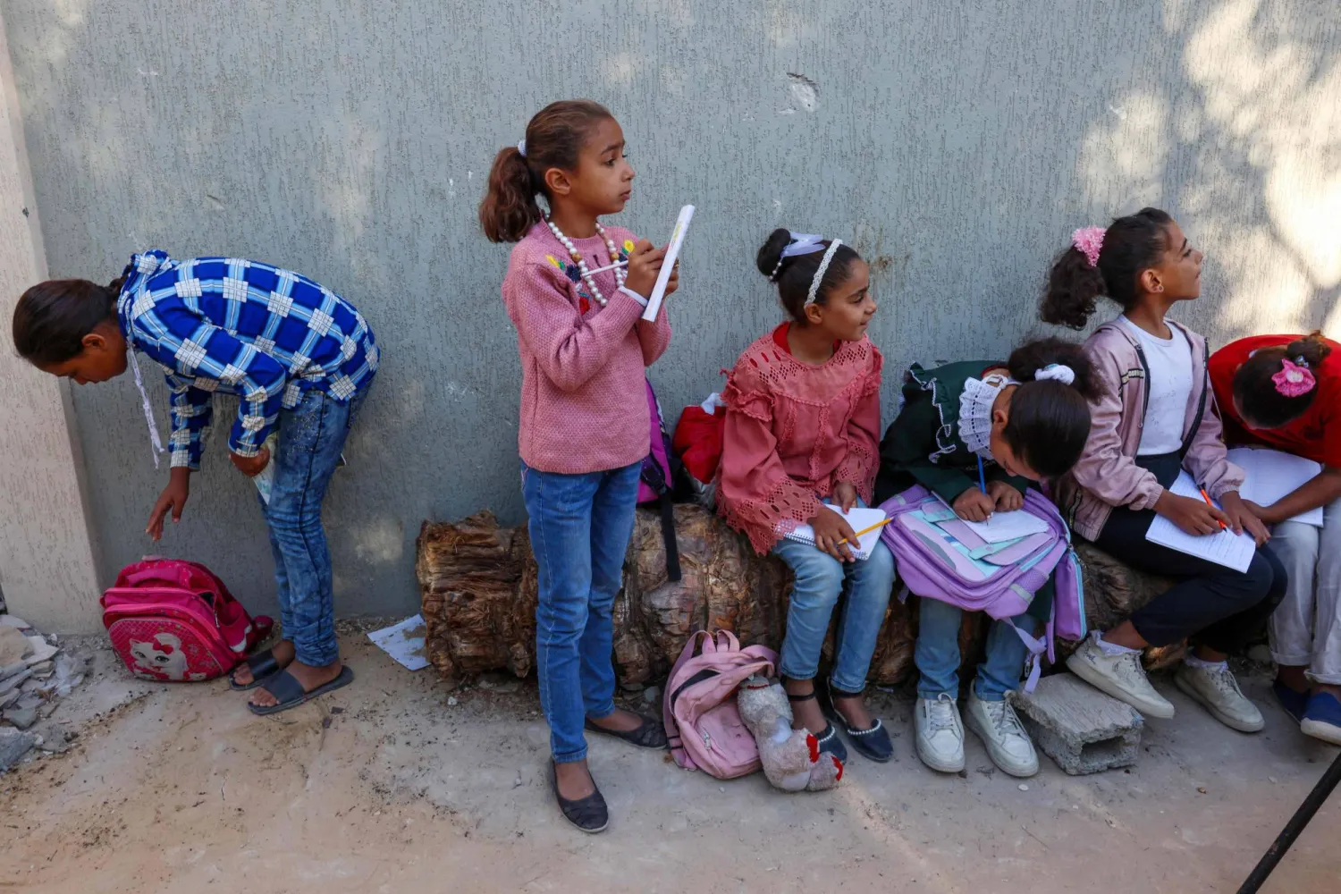 أطفال يتلقون الدروس في مخيم للنازحين بخان يونس (أ.ف.ب)