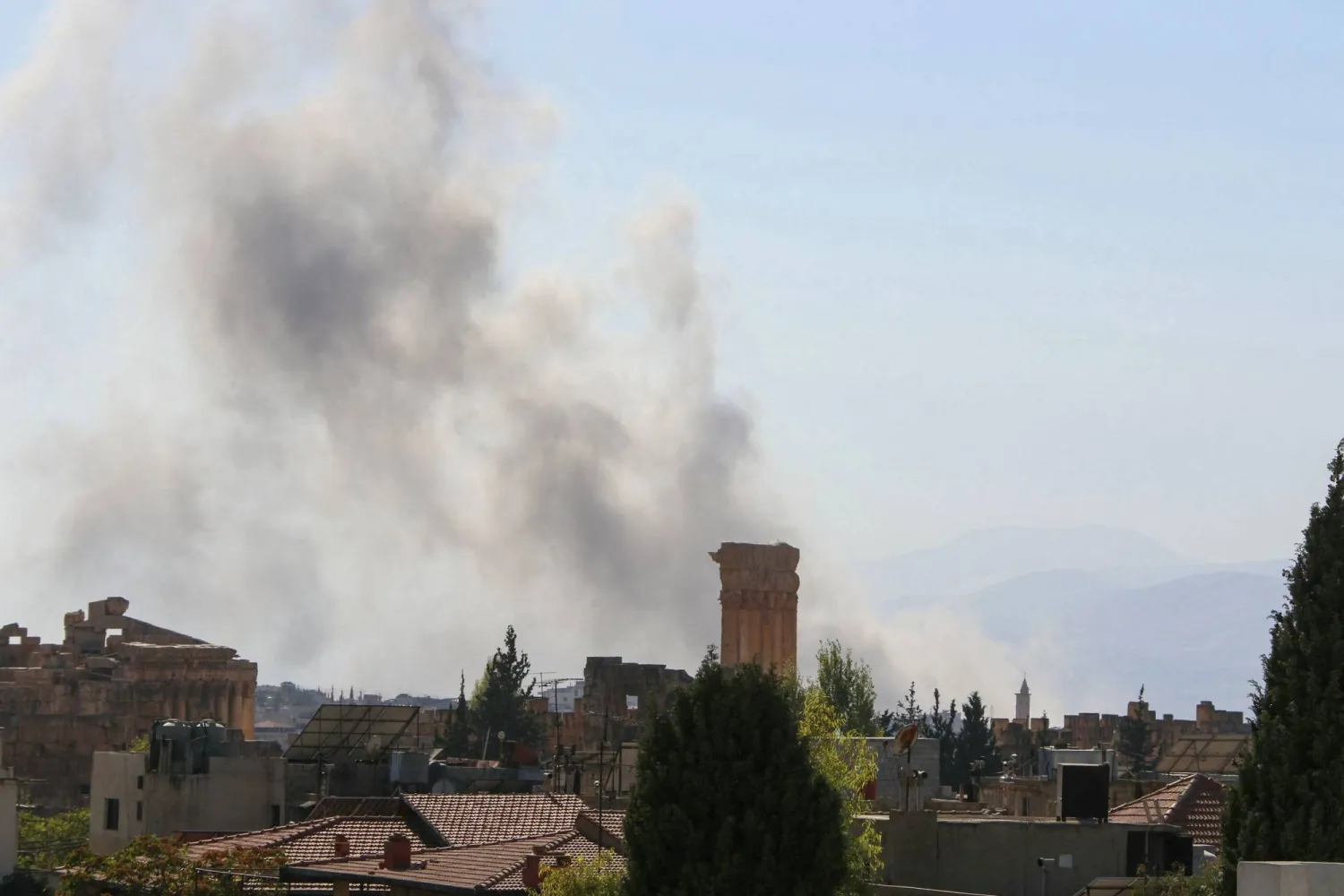 تصاعد الدخان من موقع غارة جوية إسرائيلية استهدفت منطقة على مشارف مدينة بعلبك شرق لبنان خلف أنقاض معبد باخوس الروماني القديم اليوم (أ.ف.ب)