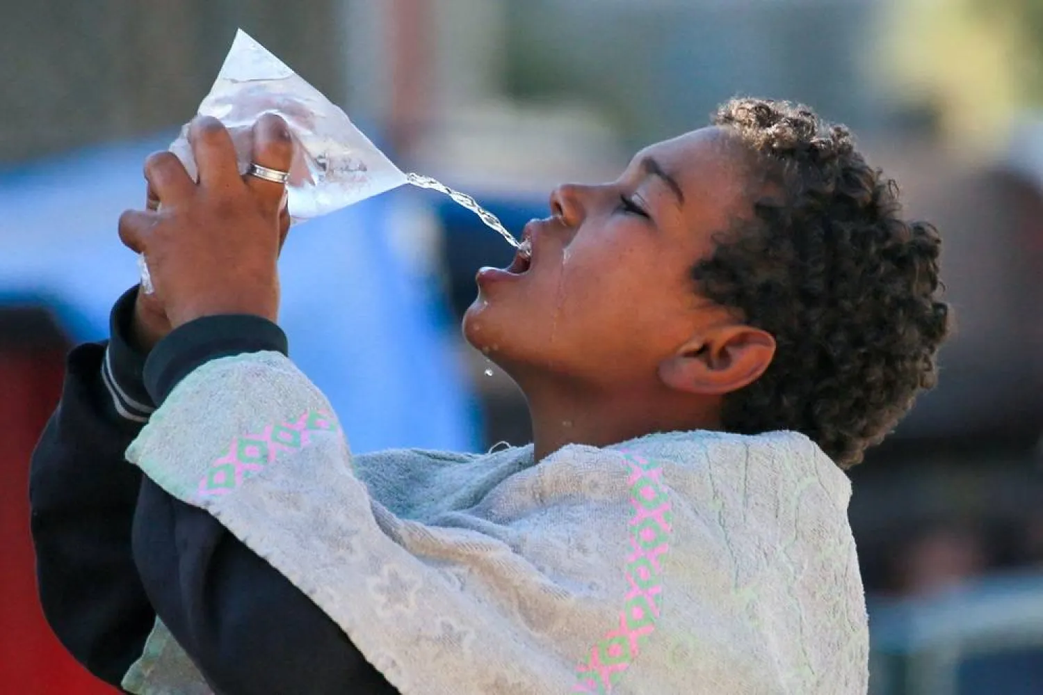  A Palestinian drinks cold water from a plastic bag in Khan Younis in Khan Yunis in the southern Gaza Strip on October 21, 2024 amid the ongoing war in the Palestinian territory between Israel and Hamas. (AFP) 