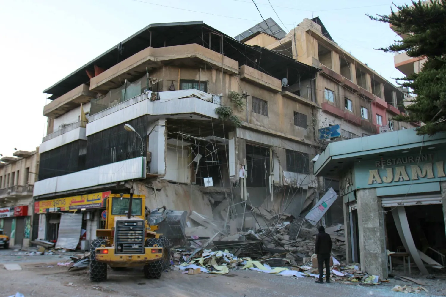 A bulldozer removes debris from the Israeli strike on the Al-Qard Al-Hassan Foundation branch in Baalbek (AFP)