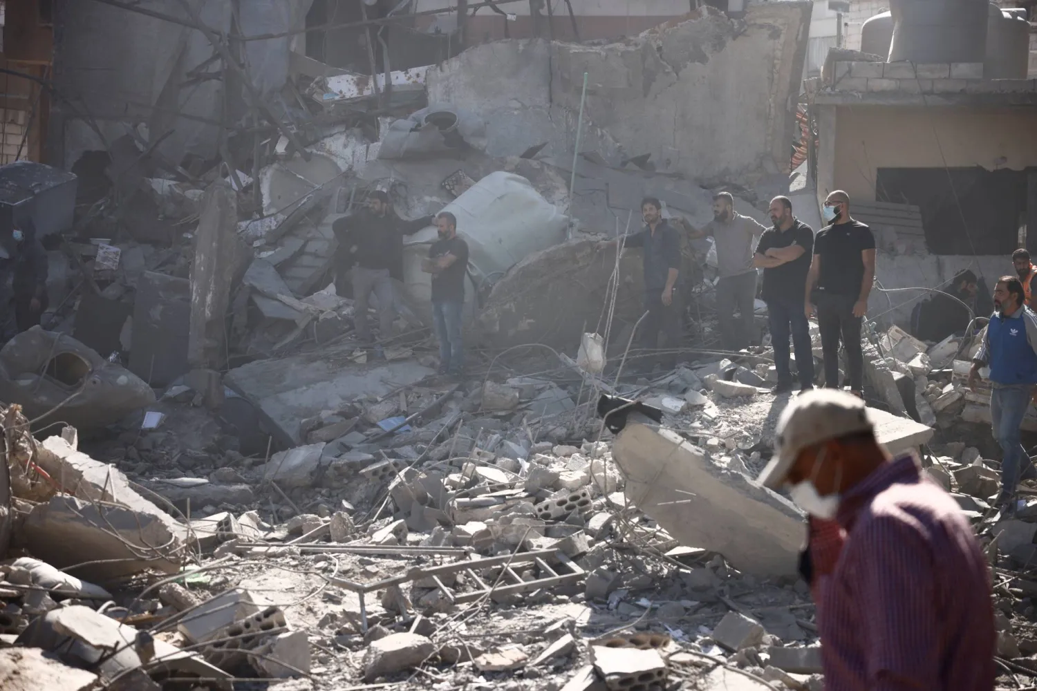 أشخاص يتفقدون الأضرار في موقع غارة إسرائيلية بالقرب من مستشفى رفيق الحريري الجامعي في بيروت (رويترز) 