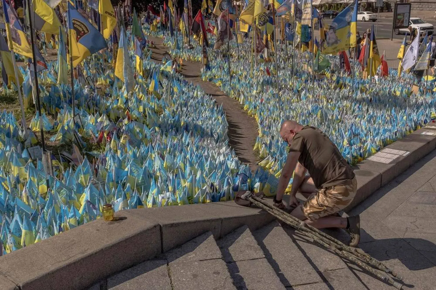 Ukrainian military veteran Viacheslav Rybachuk whose brother, a Ukrainian soldier Oleksiy was killed in Bakhmut area in 2023, kneels down at a designated area for commemorating fallen Ukrainian and foreign fighters, during the Independence Day of Ukraine, in the Independence Square in Kyiv, on August 24, 2024.(AFP)