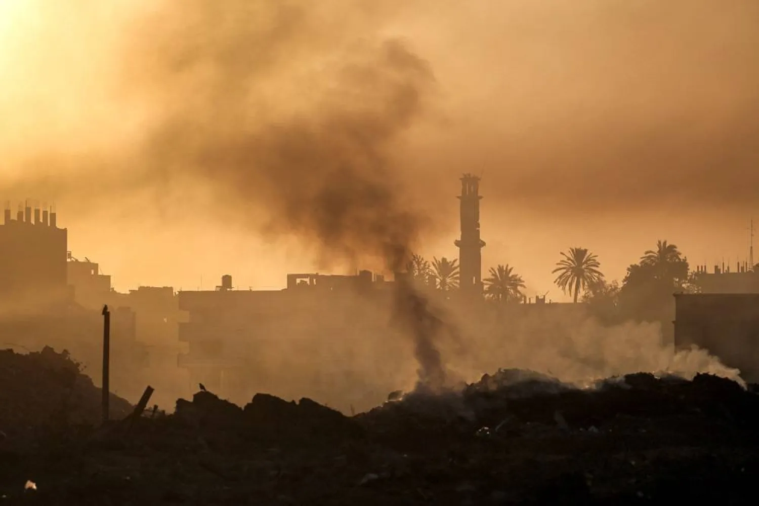  Smoke from burning garbage trails amidst early morning fog near a damaged mosque in Deir el-Balah in the center of the Gaza Strip on October 22, 2024 amid the ongoing war in the Palestinian territory between Israel and Hamas. (AFP) 