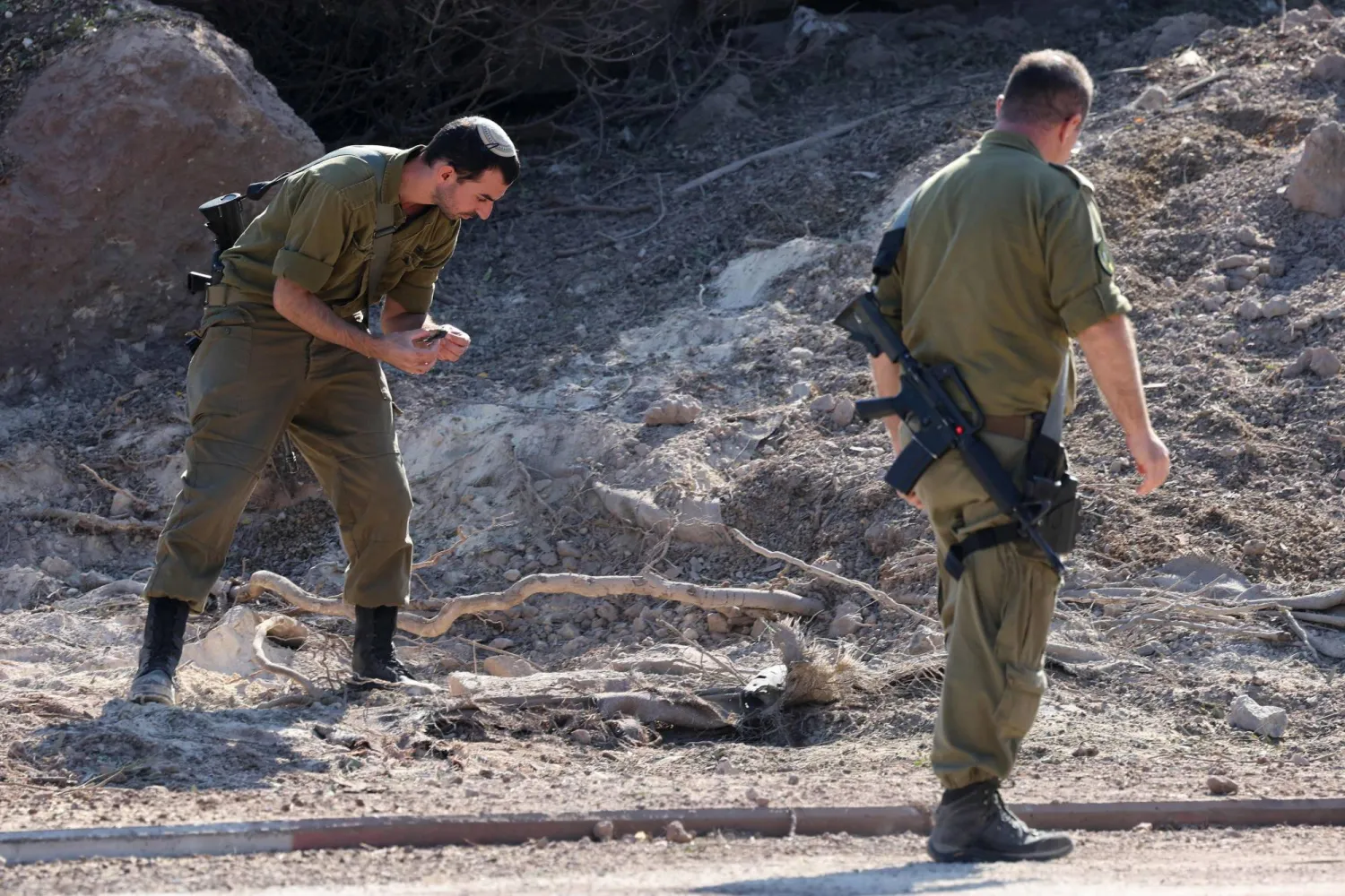 جنود إسرائيليون يجمعون الحطام من موقع هجوم صاروخي أُطلق من لبنان على كيبوتس معجان ميخائيل جنوب حيفا في 22 أكتوبر 2024 وسط الحرب المستمرة بين إسرائيل و«حزب الله» (أ.ف.ب)