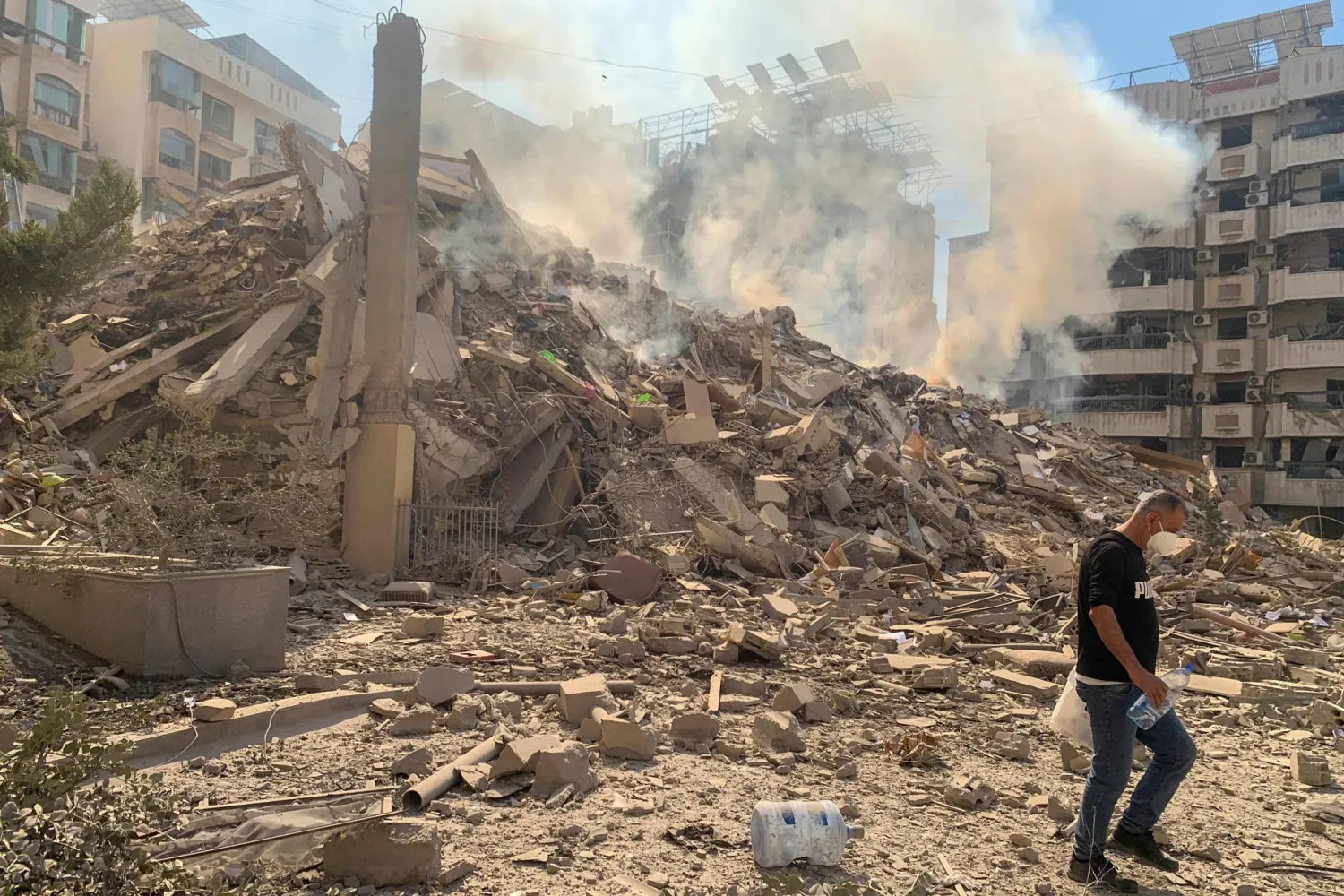 رجل يسير بين أنقاض مبنى مدمر في الضاحية الجنوبية لبيروت (أ.ف.ب)