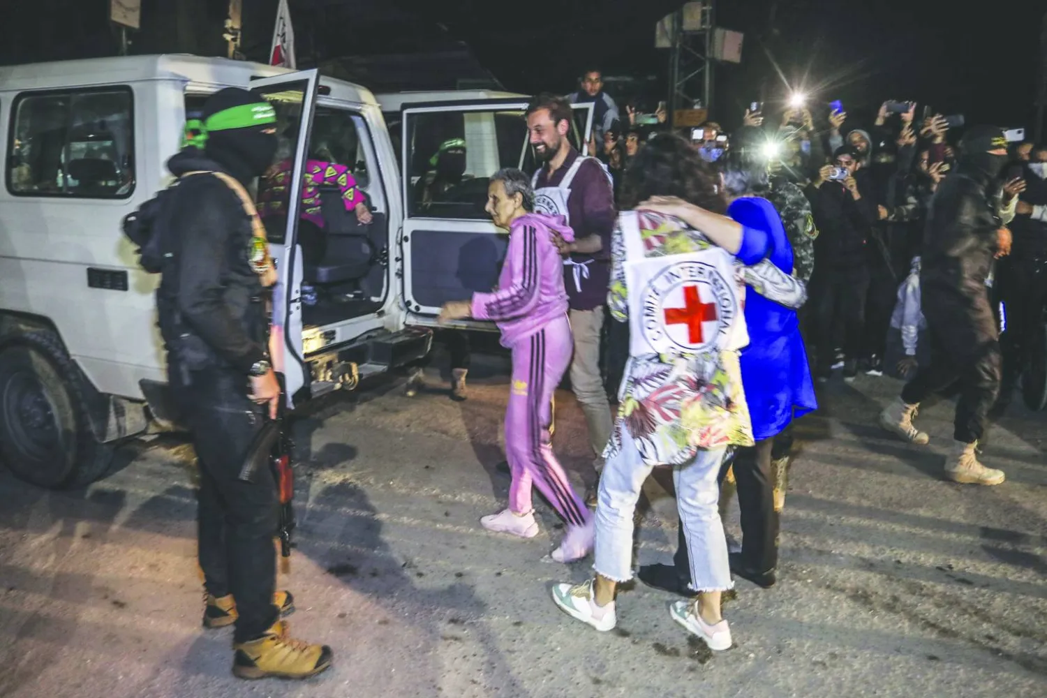 عناصر من «حماس» و«الجهاد الإسلامي» يسلمون محتجزين مفرج عنهم إلى «الصليب الأحمر» في رفح 28 نوفمبر 2023 ضمن صفقة تبادل الرهائن والأسرى بين «حماس» وإسرائيل (د.ب.أ)