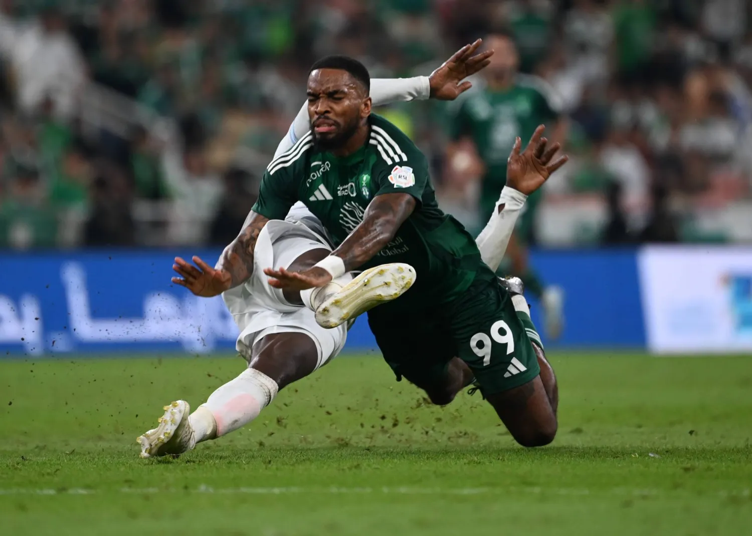 إيفان توني لاعب الأهلي يتعرض للسقوط بعد اصطدامه بلاعب الأخدود (تصوير: علي خمج)