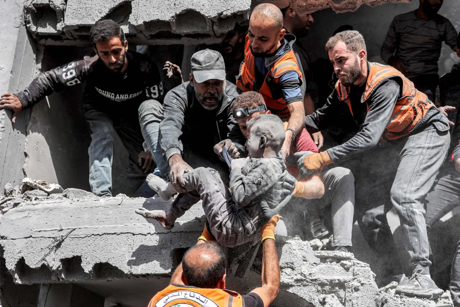 أفراد الدفاع المدني الفلسطيني ينقذون طفلاً إثر قصف إسرائيلي على منزل عائلة في حي الزرقاء شمال مدينة غزة في 26 أكتوبر 2024 (أ.ف.ب)