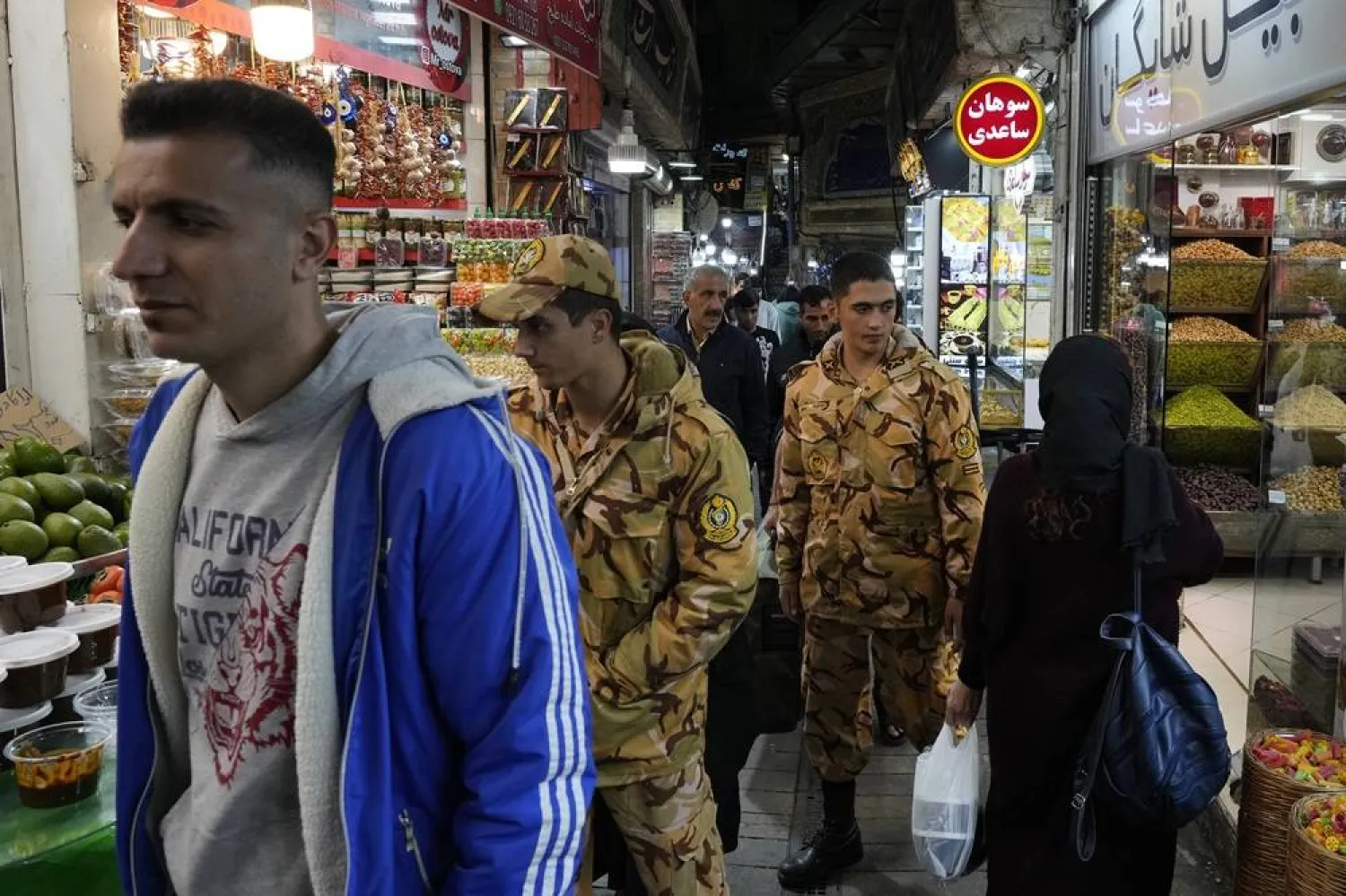  Two army soldiers and people walk through Tajrish traditional bazaar in northern Tehran, Iran, Saturday, Oct. 26, 2024. (AP)