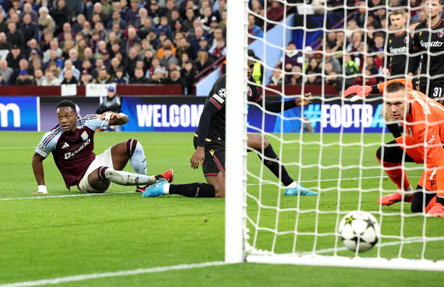 دوران على الأرض (يسار) يسجل ثاني أهداف أستون فيلا في مرمى بولونيا الإيطالي بدوري الأبطال (إ.ب.أ)