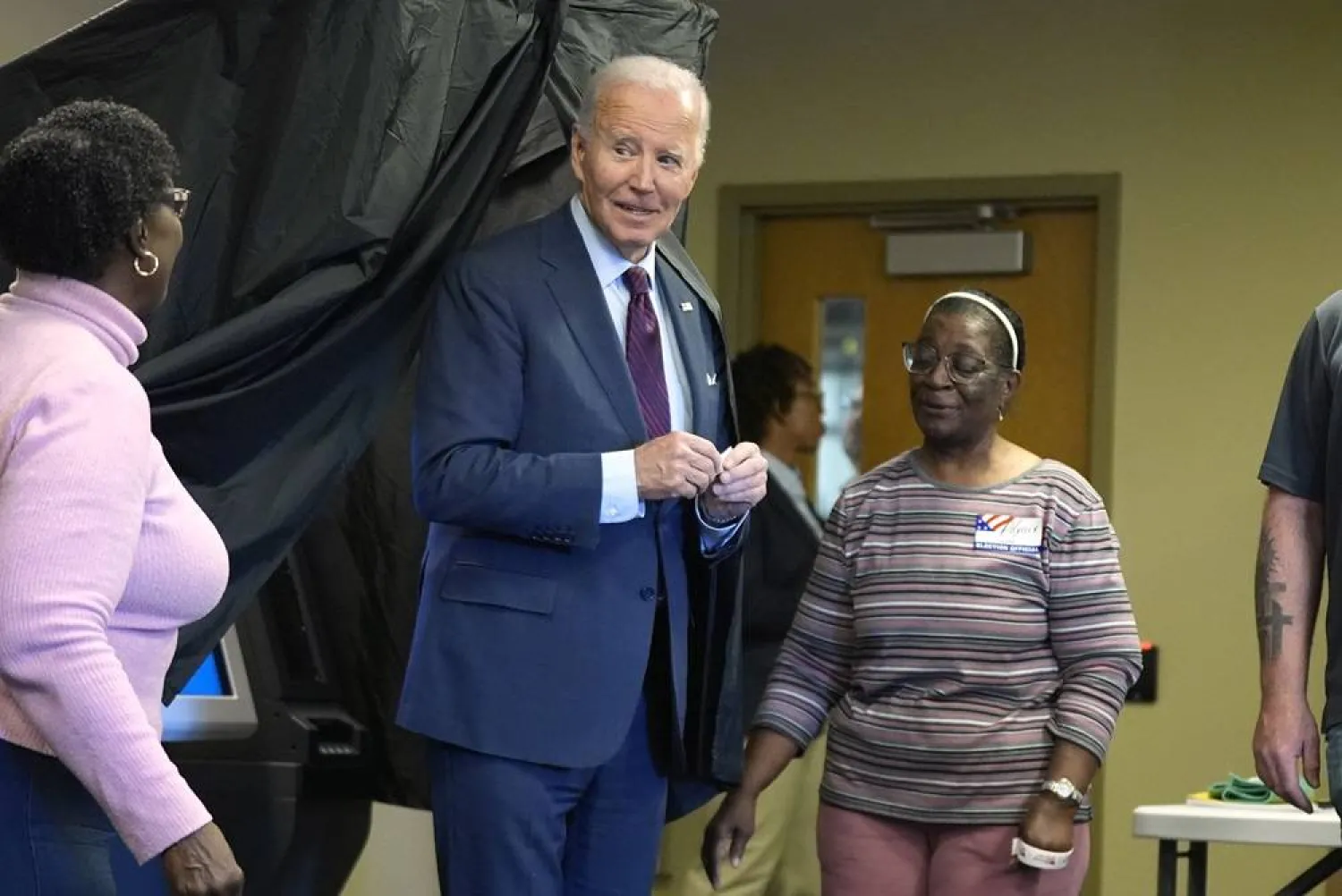  President Joe Biden, center, holds an "I Voted Early" sticker upon exiting the voting booth after casting his early-voting ballot for the 2024 general elections, Monday, Oct. 28, 2024, in New Castle, Del. (AP) 