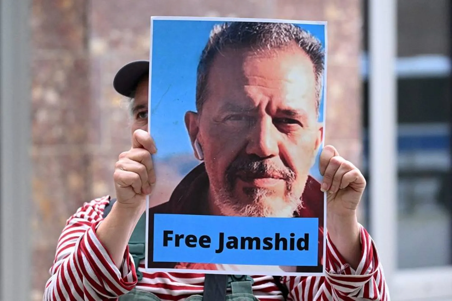 In this file photo taken on July 31, 2023 a demonstrator holds a picture of Iranian-German Jamshid Sharmahd, who has been sentenced to death in Iran, and with the lettering "Free Jamshid" during a demonstration for his release in front of the German Foreign Ministry in Berlin. (AFP)