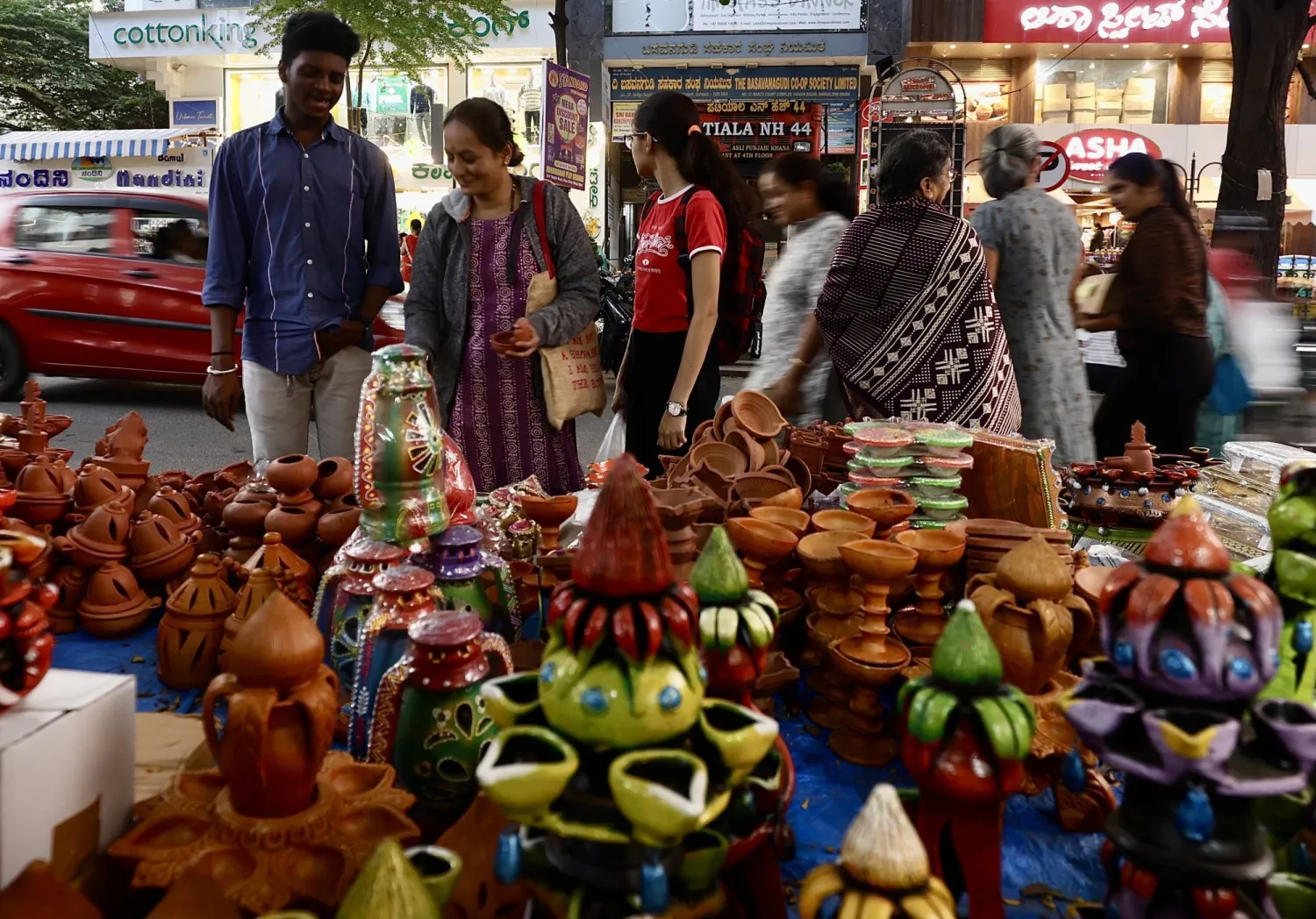 أشخاص يزورون متاجر المصابيح الفخارية والأضواء الزخرفية قبل مهرجان ديوالي في بنغالور (إ.ب.أ)