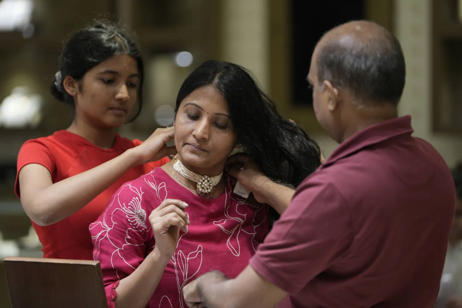 امرأة ترتدي قلادةً أثناء التسوق خلال اليوم الذي يمثل بداية مهرجان الأضواء الهندوسي (أ.ب)