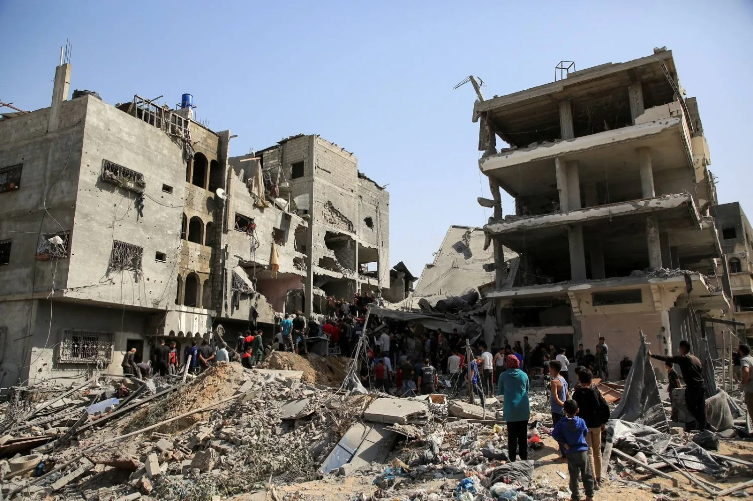 فلسطينيون في موقع غارة إسرائيلية على منزل بمدينة غزة (رويترز)