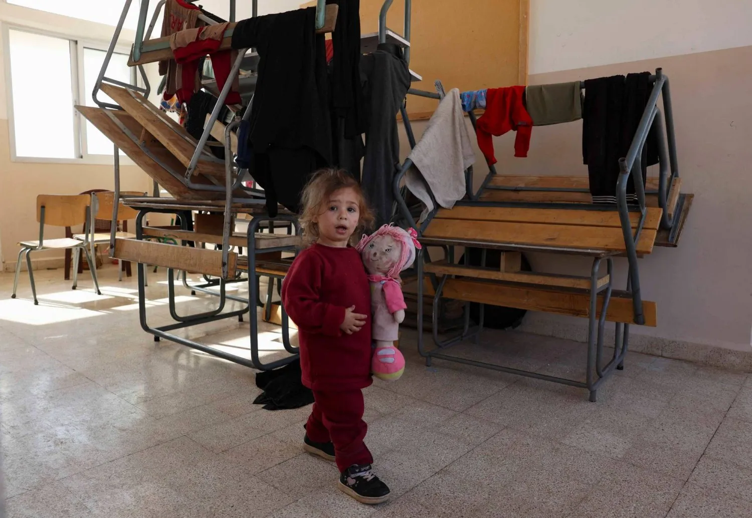A girl walks inside a school turned into a shelter housing displaced people who fled from Baalbek and surrounding areas, in Deir Al-Ahmar, Lebanon (Reuters)