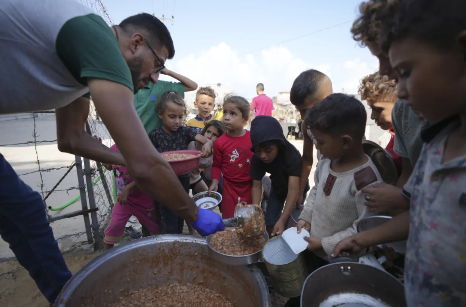 Displaced Palestinian children queue for food in a camp in Deir al-Balah, Gaza Strip, Friday, Oct. 18, 2024. (AP - Photo/Abdel Kareem Hana)