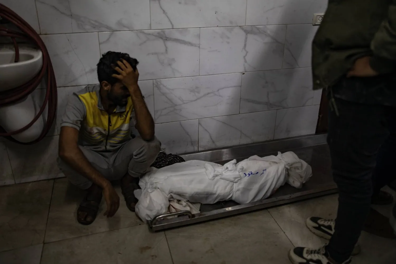 Bir Filistinli, İsrail baskınının ardından Nasser Hastanesi'nde bir aile ferdinin cesedinin yanında (EPA)