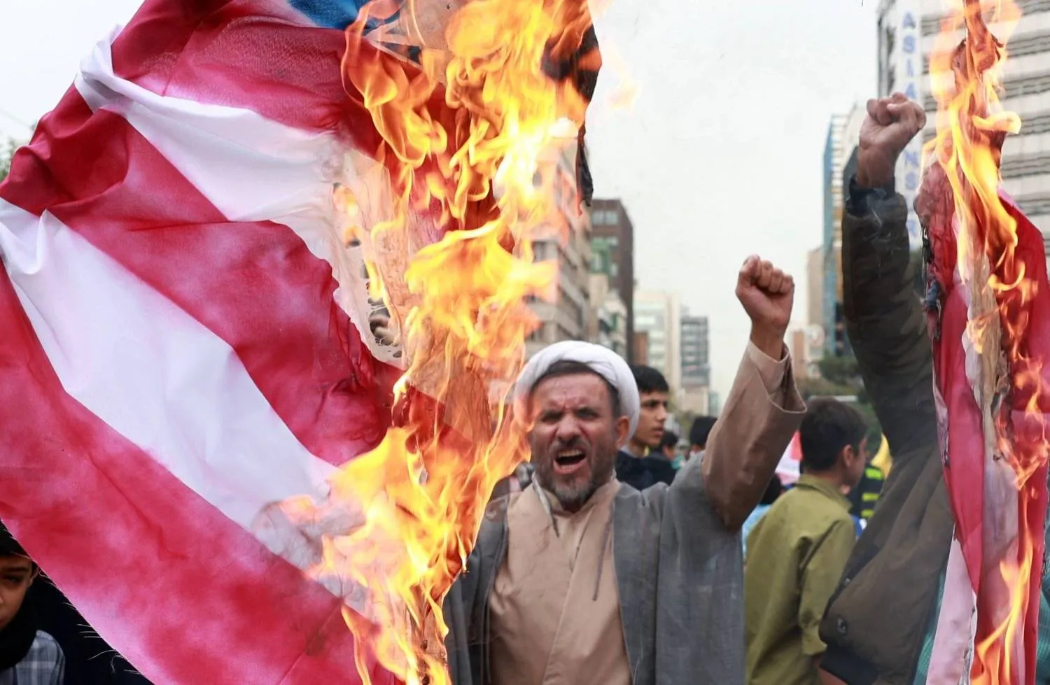 An Iranian cleric chants slogans as Iranians burn a US flag during an anti-US rally marking the 45th anniversary of the US Embassy takeover, in front of the former embassy building in Tehran, Iran, 03 November 2024. EPA/ABEDIN TAHERKENAREH