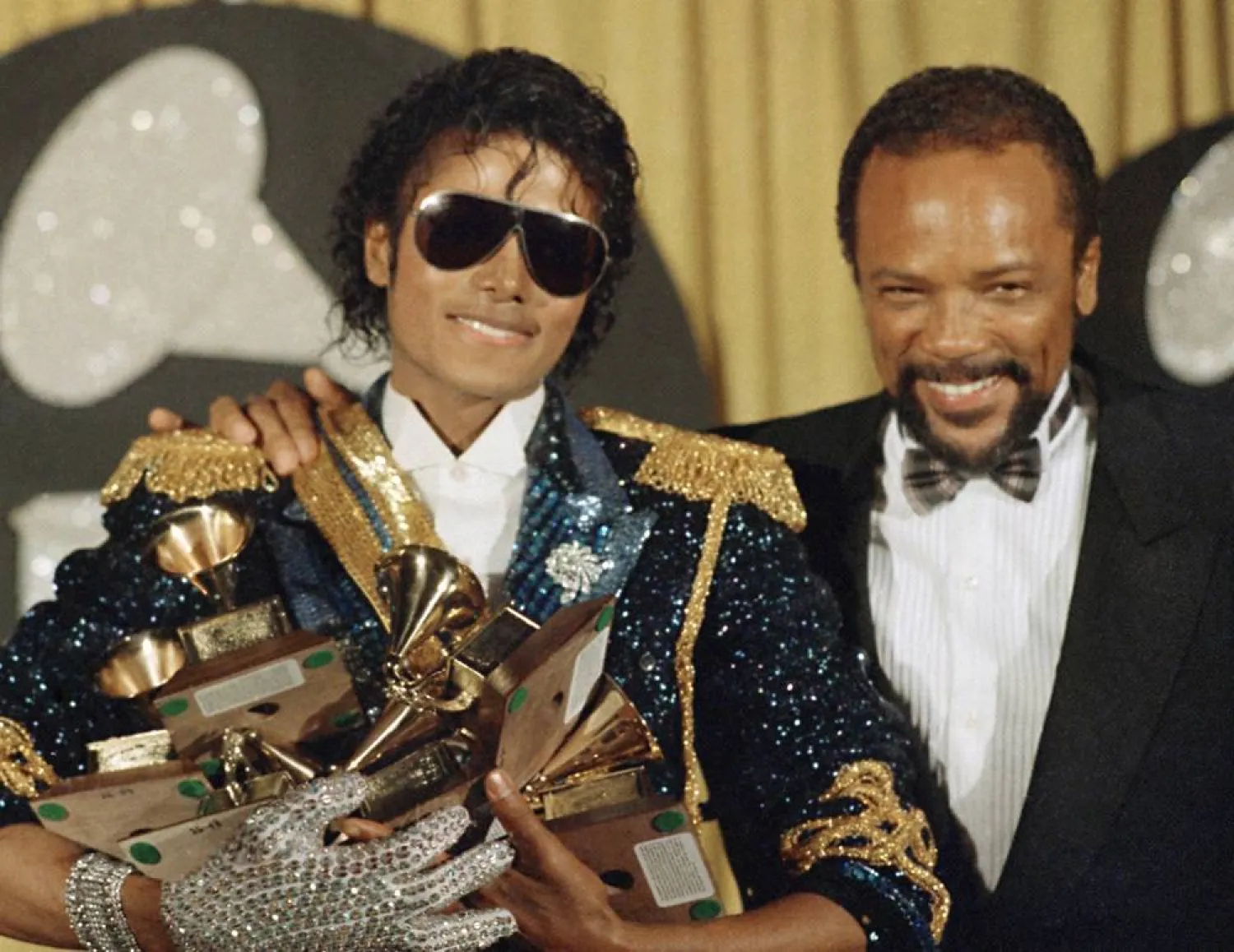 Michael Jackson, left, holds eight awards as he poses with Quincy Jones at the Grammy Awards in Los Angeles, Feb. 28, 1984. (AP)